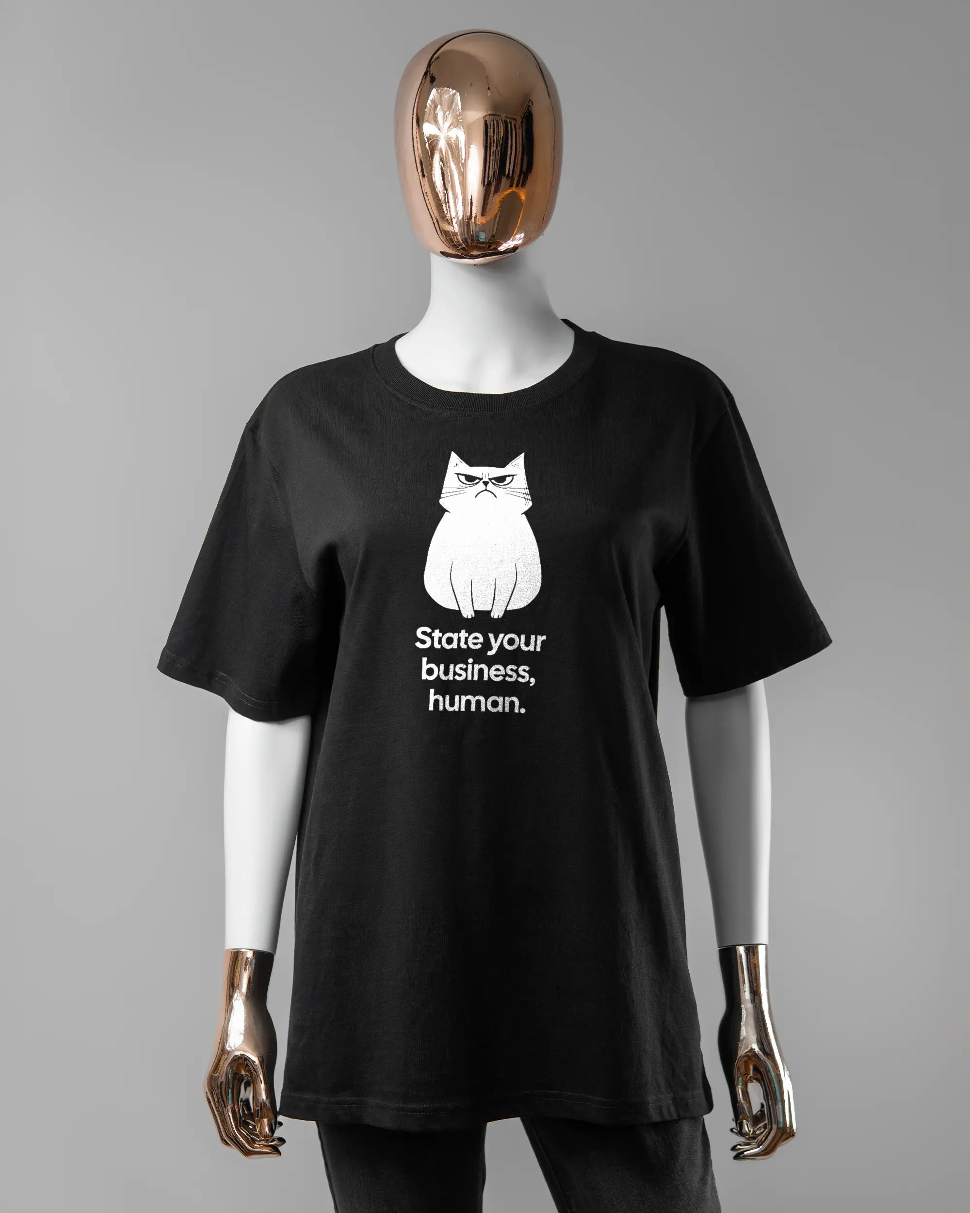 Vorderseite des Organic Unisex T-Shirt Relaxed von Maondo mit dem Design Grumpy Purr in der Farbe Black und in der Größe S getragen von einer femininen Puppe
