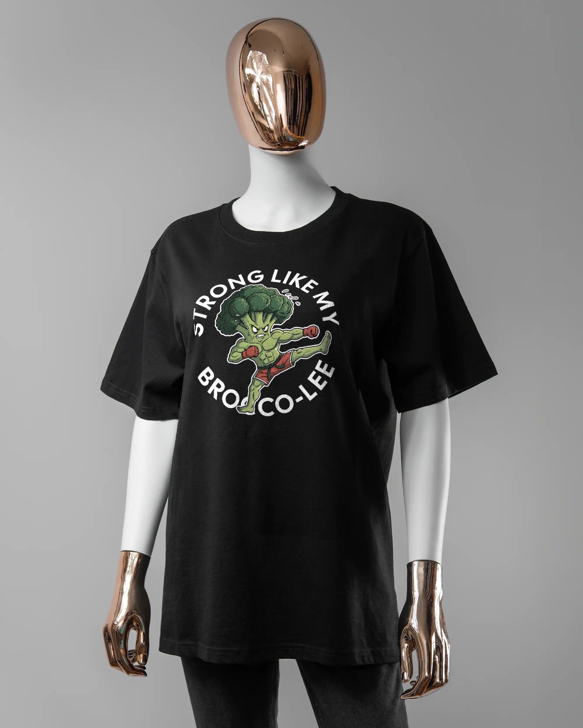 Vorderseite des Organic Unisex T-Shirt Relaxed von Maondo mit dem Design Brocco-Lee in der Farbe Black und in der Größe S getragen von einer femininen Puppe