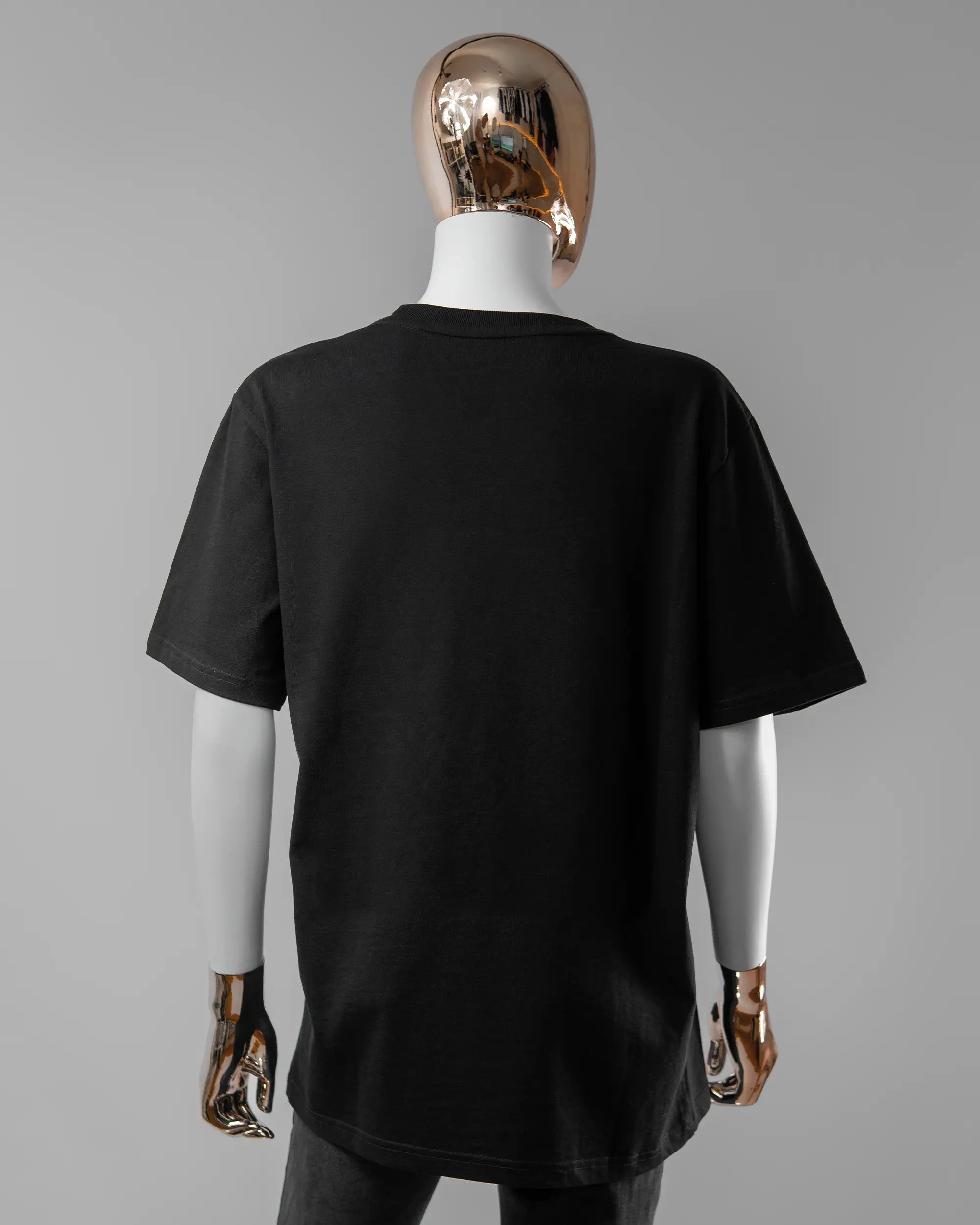 Rückseite des Organic Unisex T-Shirt Relaxed von Maondo ohne Motiv in der Farbe Black und in der Größe S getragen von einer femininen Puppe