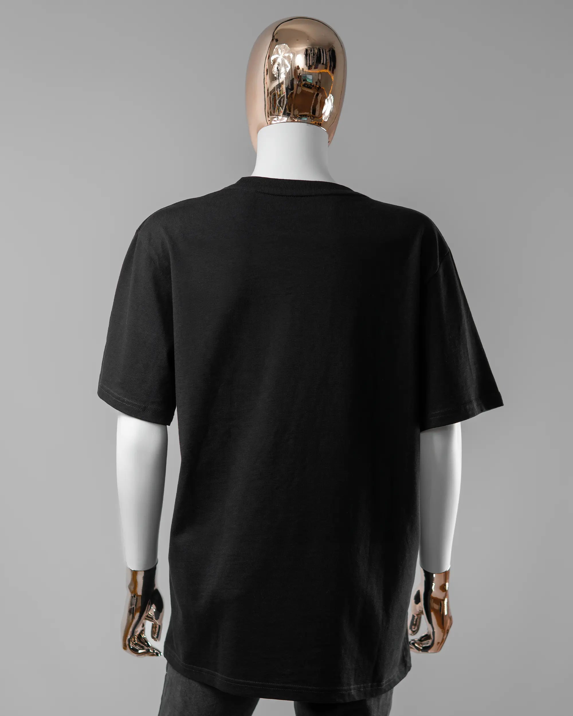 Rückseite des Organic Unisex T-Shirt Relaxed von Maondo ohne Motiv in der Farbe Black und in der Größe S getragen von einer femininen Puppe