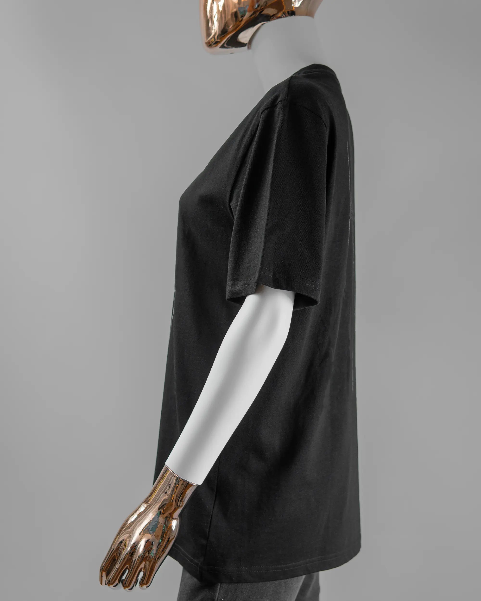 Seitenansicht des Organic Unisex T-Shirt Relaxed von Maondo mit dem Design Ducked Up vorne in der Farbe Black und in der Größe S getragen von einer femininen Puppe