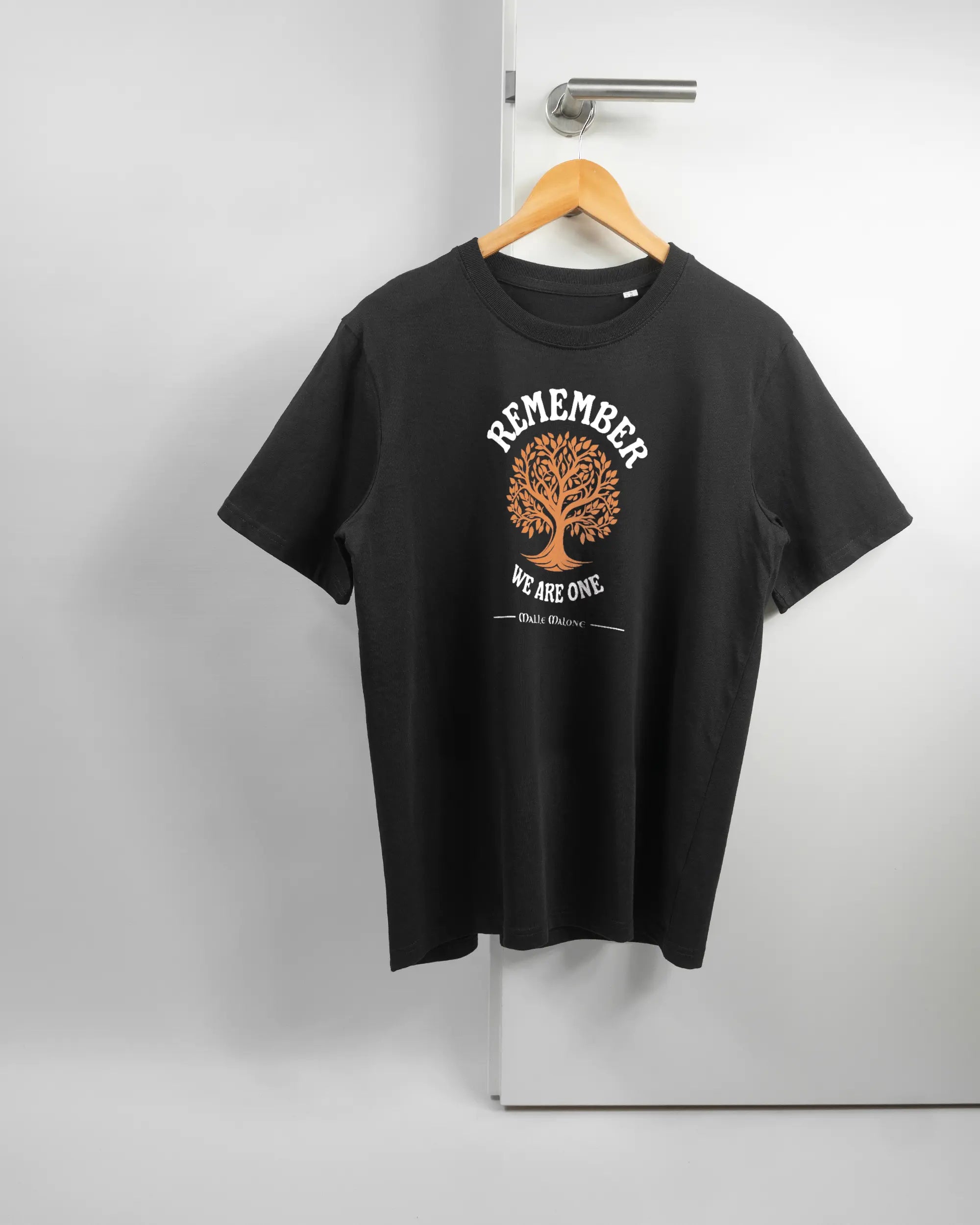 Vorderseite des Organic Unisex T-Shirt Relaxed von Maondo mit dem Design We are one in der Farbe Black und in der Größe S auf einem Bügel an der Türklinke aufgehängt
