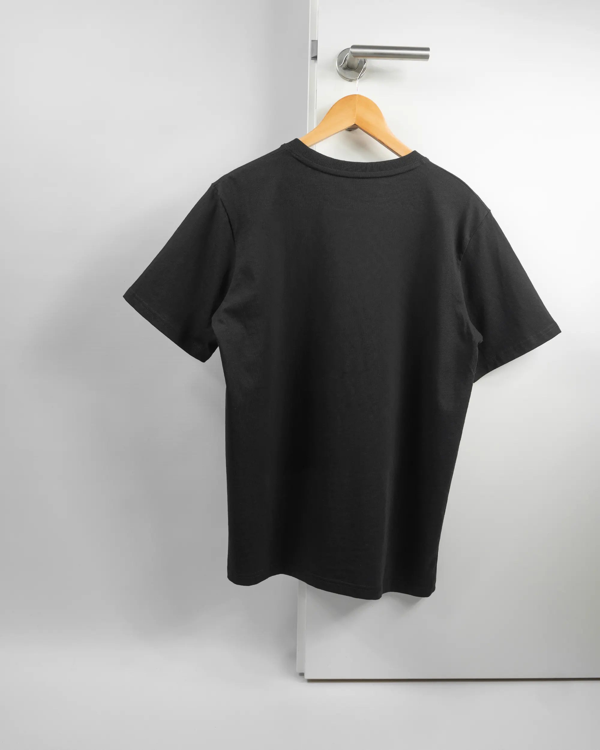 Rückseite des Organic Unisex T-Shirt Relaxed von Maondo ohne Motiv in der Farbe Black und in der Größe S auf einem Bügel an der Türklinke aufgehängt