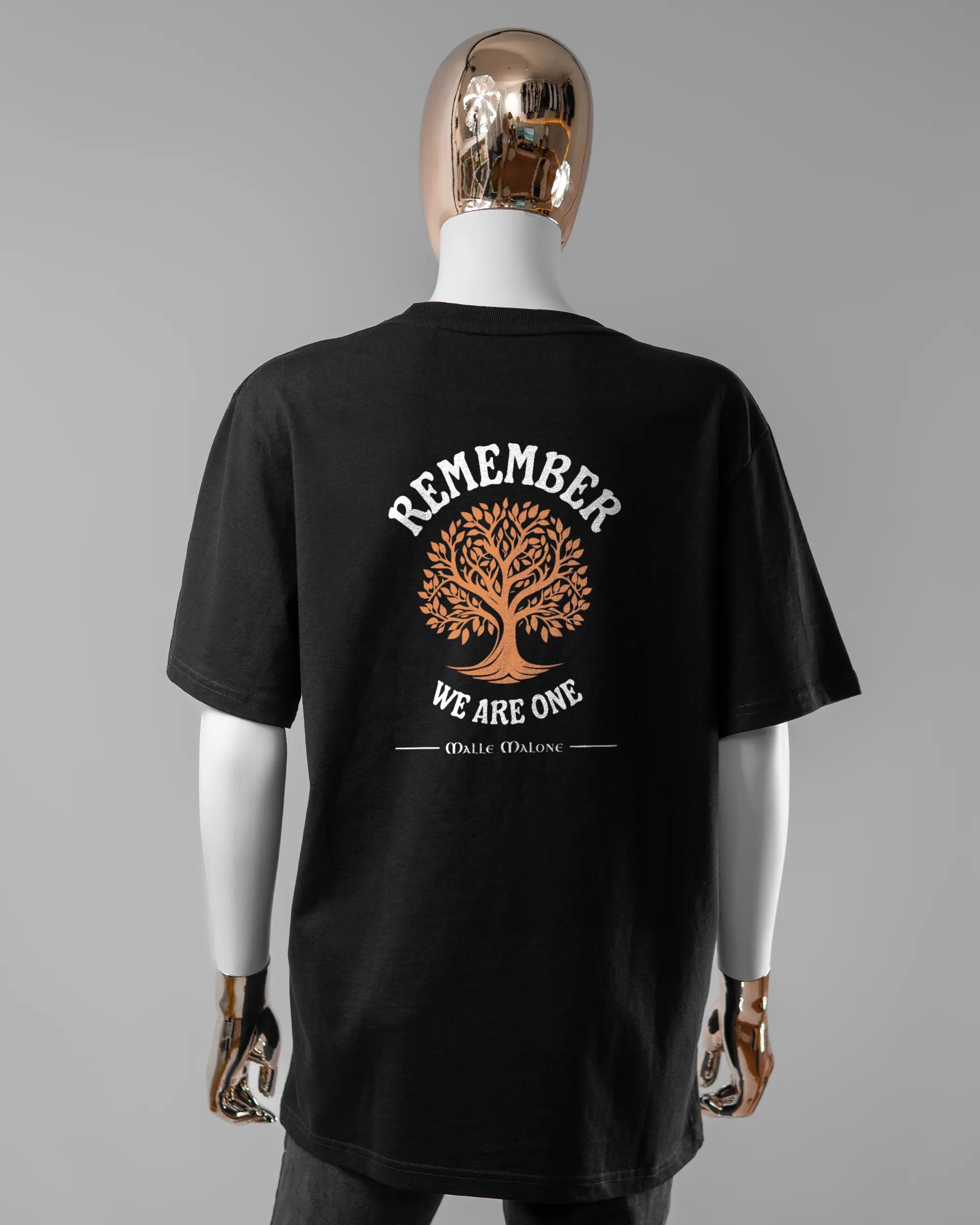 Rückseite des Organic Unisex T-Shirt Relaxed von Maondo mit dem Design We are one in der Farbe Black und in der Größe S getragen von einer femininen Puppe