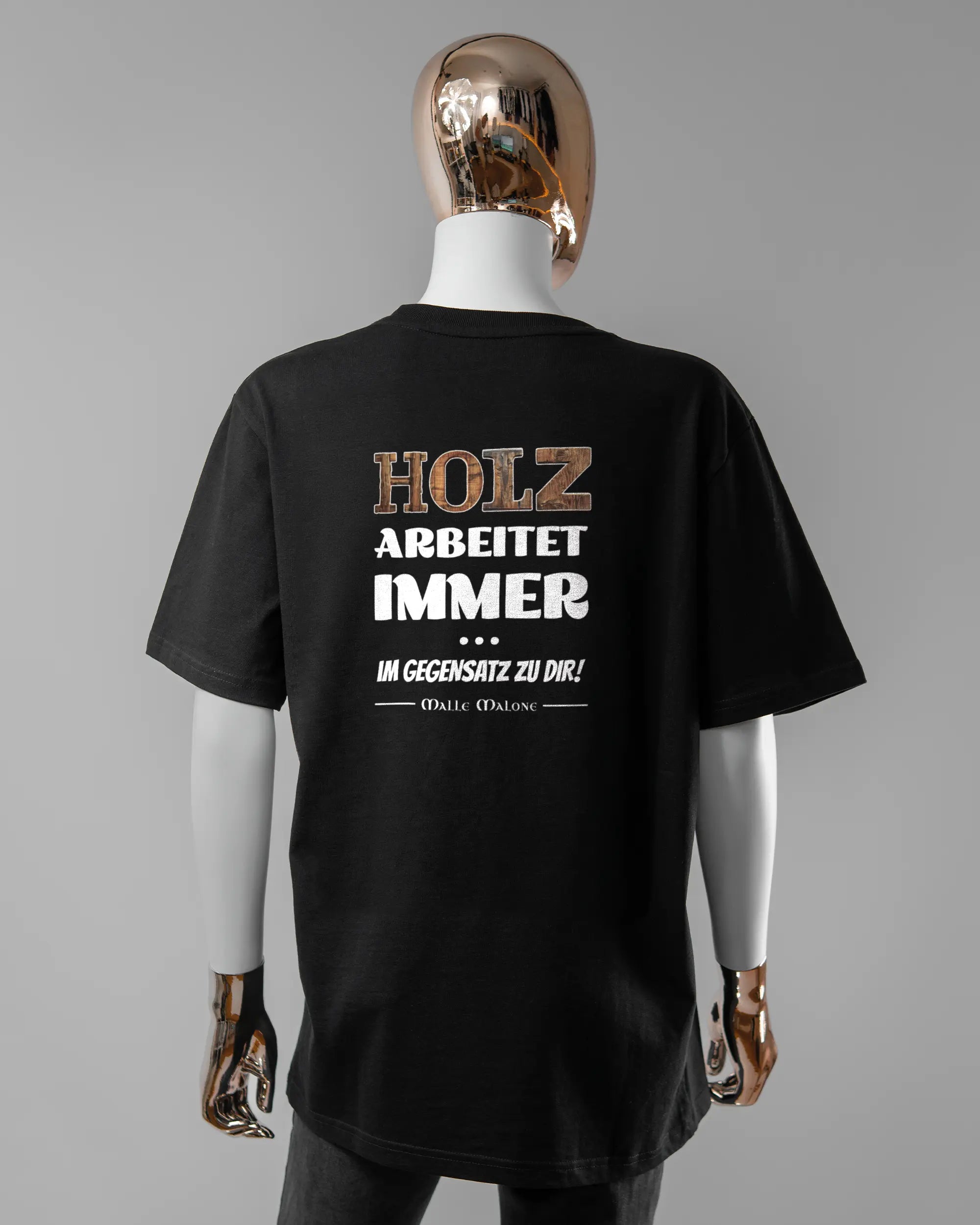 Rückseite des Organic Unisex T-Shirt Relaxed von Maondo mit dem Design Holzarbeit in der Farbe Black und in der Größe S getragen von einer femininen Puppe