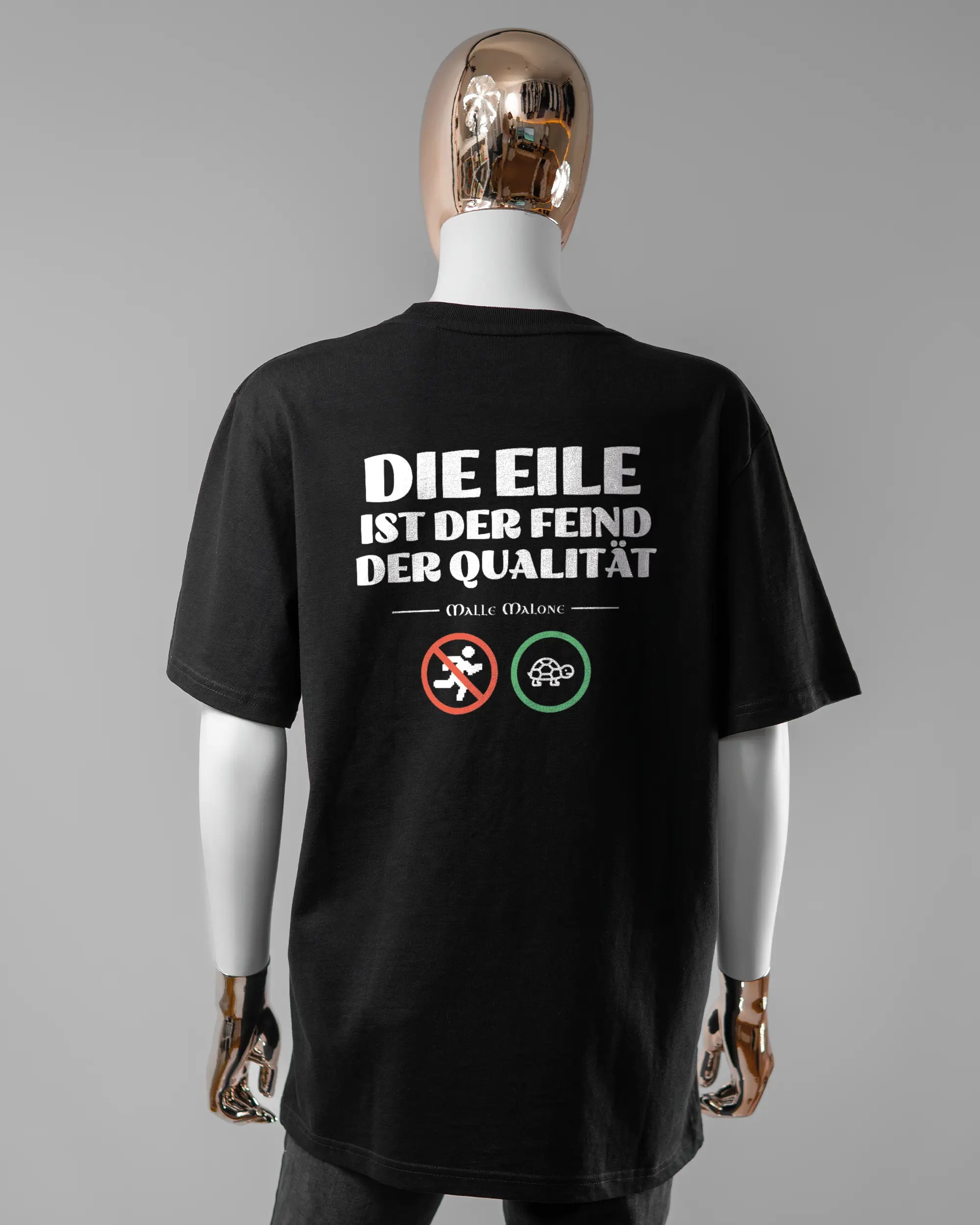 Rückseite des Organic Unisex T-Shirt Relaxed von Maondo mit dem Design Keine Eile in der Farbe Black und in der Größe S getragen von einer femininen Puppe