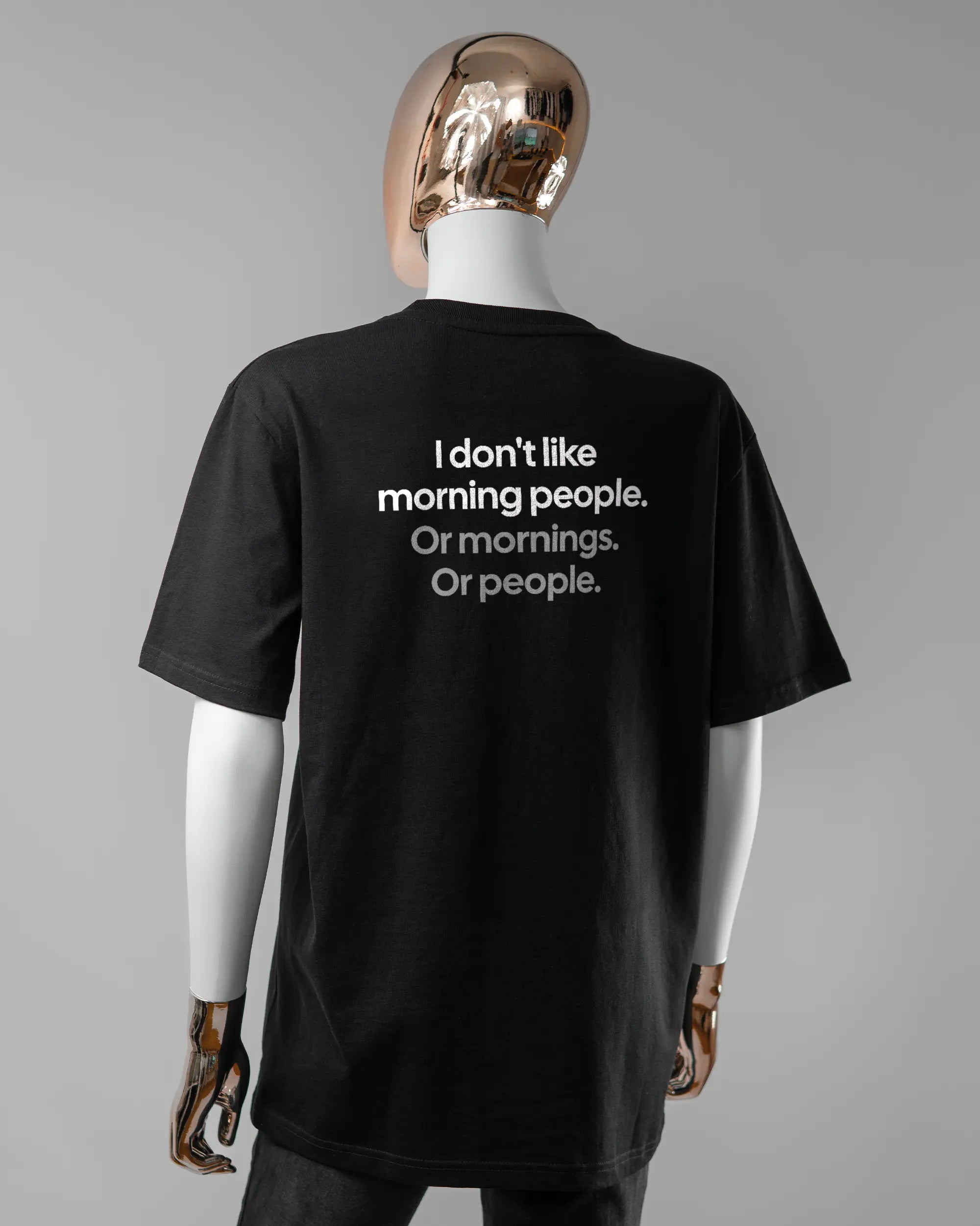 Rückseite des Organic Unisex T-Shirt Relaxed von Maondo mit dem Design Morning Person in der Farbe Black und in der Größe S getragen von einer femininen Puppe