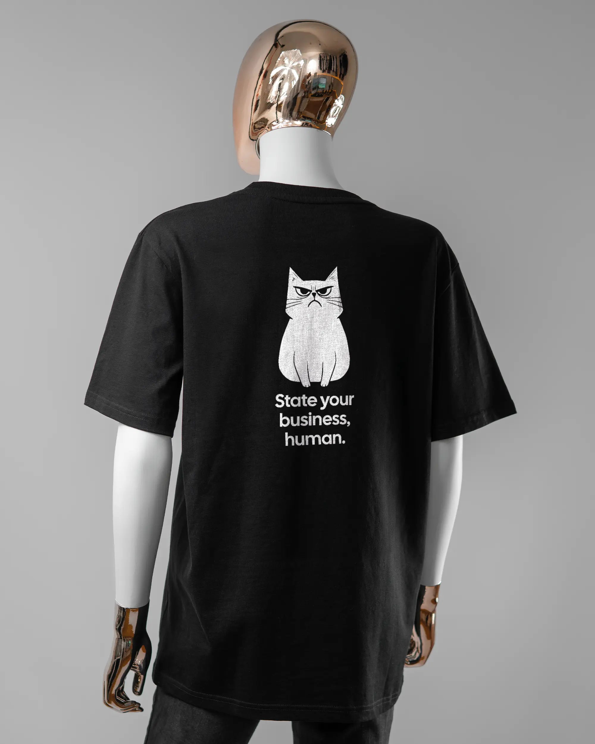 Rückseite des Organic Unisex T-Shirt Relaxed von Maondo mit dem Design Grumpy Purr in der Farbe Black und in der Größe S getragen von einer femininen Puppe