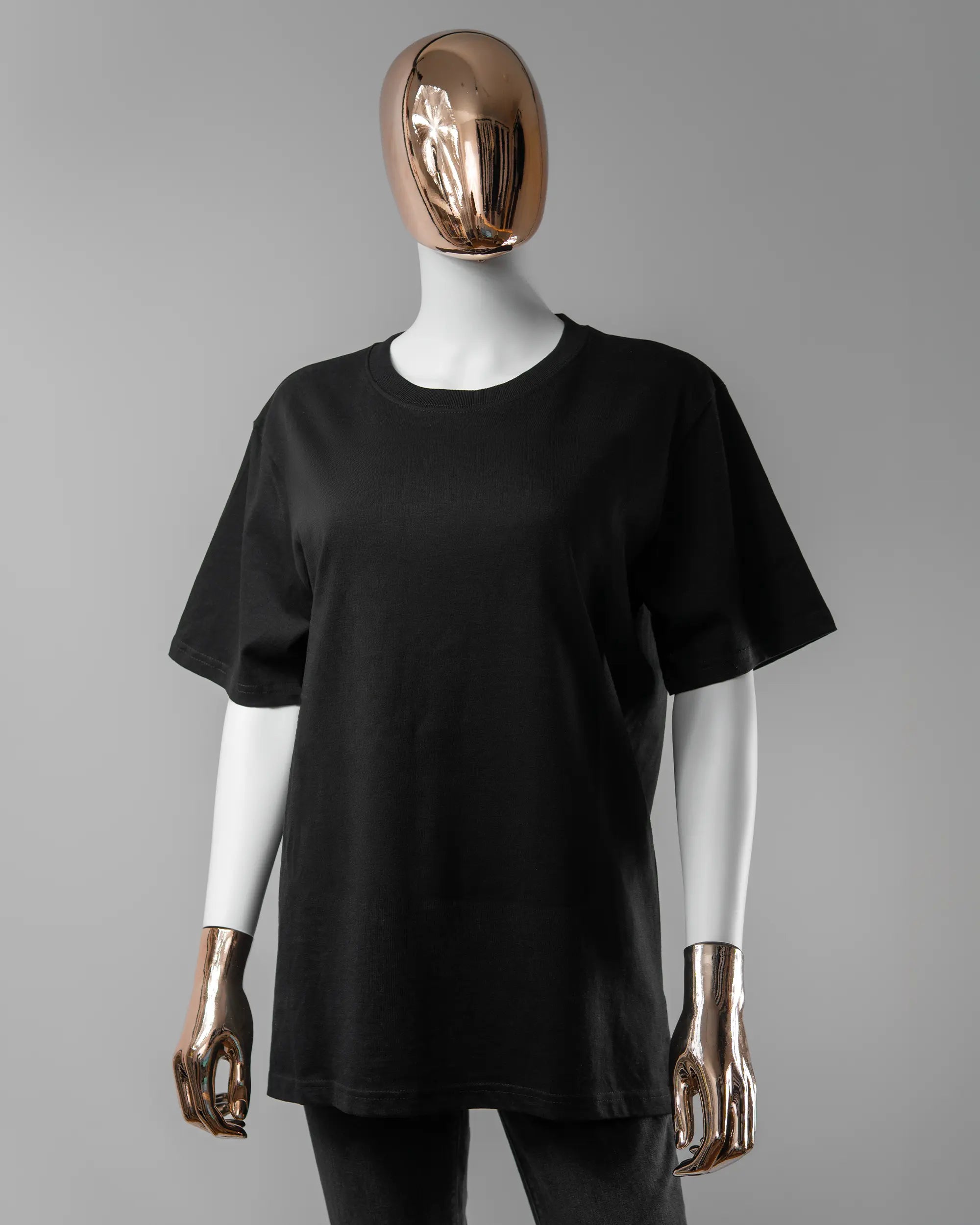 Vorderseite des Organic Unisex T-Shirt Relaxed von Maondo ohne Motiv in der Farbe Black und in der Größe S getragen von einer femininen Puppe