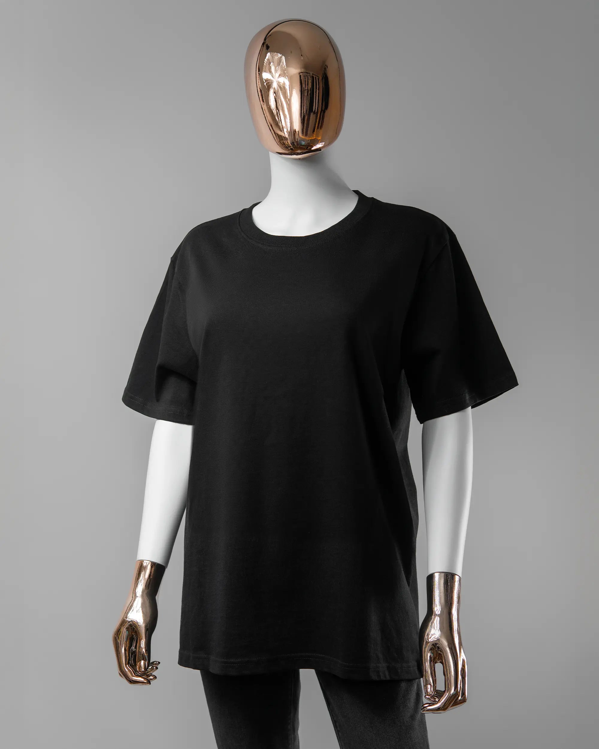 Vorderseite des Organic Unisex T-Shirt Relaxed von Maondo ohne Motiv in der Farbe Black und in der Größe S getragen von einer femininen Puppe