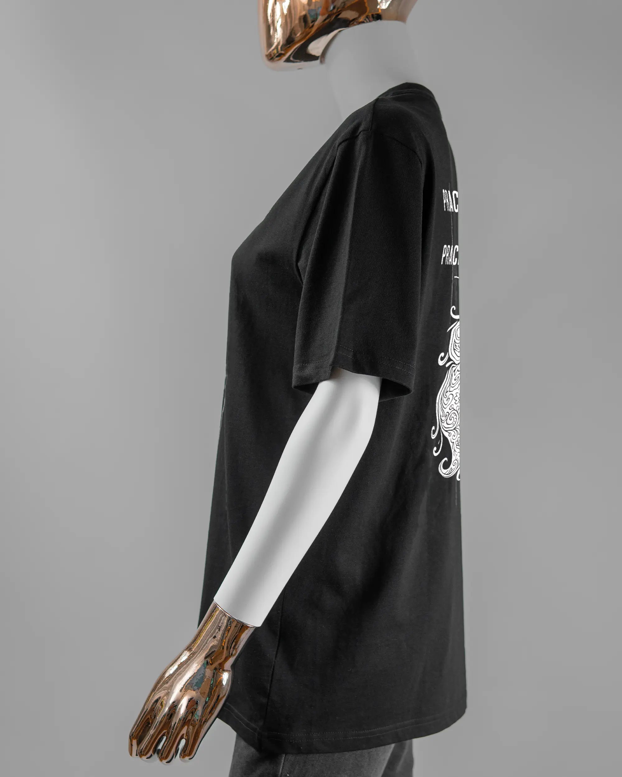 Seitenansicht des Organic Unisex T-Shirt Relaxed von Maondo mit dem Design Trachtentanz hinten in der Farbe Black und in der Größe S getragen von einer femininen Puppe