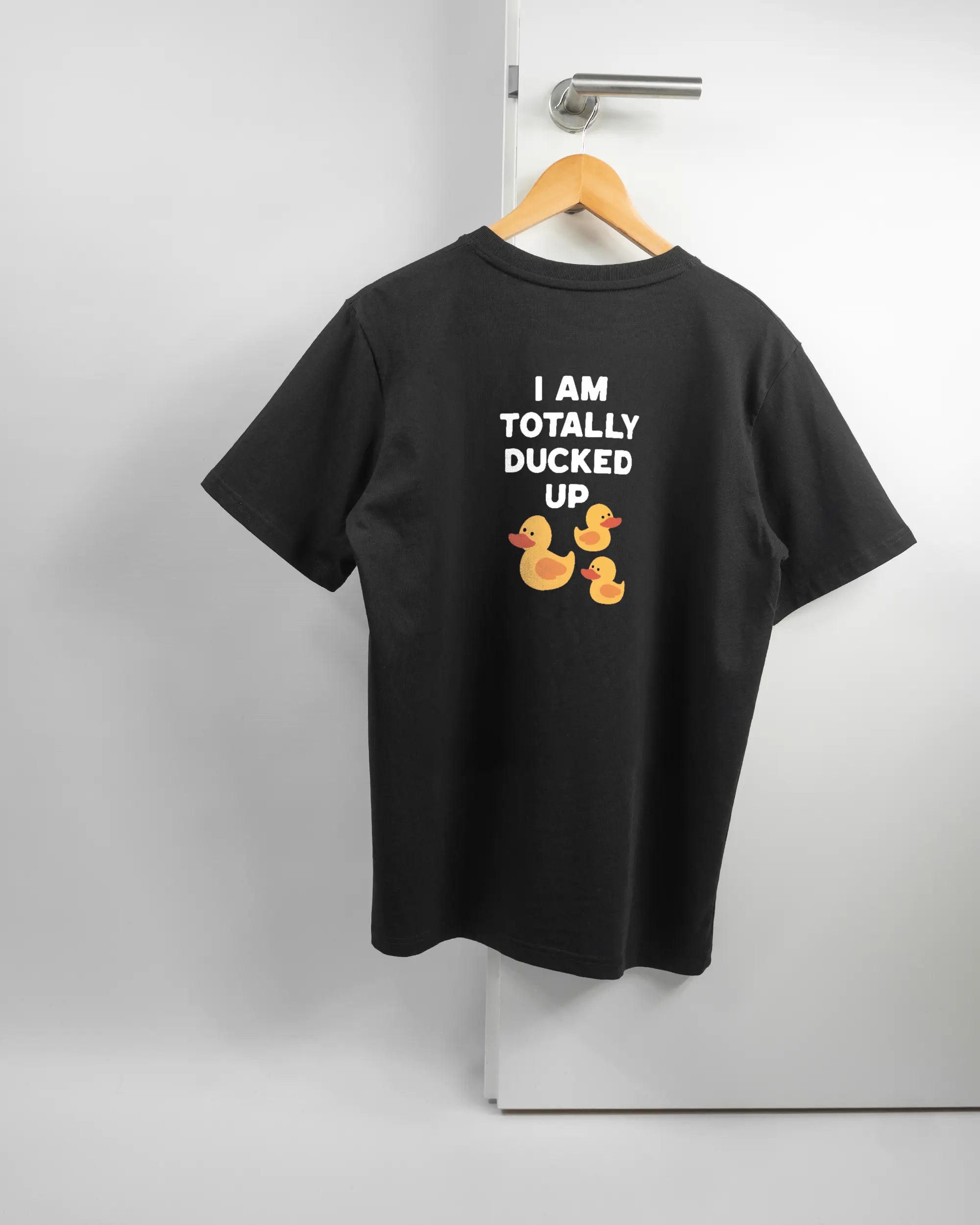 Rückseite des Organic Unisex T-Shirt Relaxed von Maondo mit dem Design Ducked Up in der Farbe Black und in der Größe S auf einem Bügel an der Türklinke aufgehängt