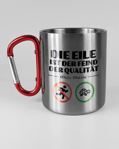Titelbild, das die linke Seite der beidseitig bedruckten Edelstahltasse von Maondo mit dem Design Keine Eile in der Farbe Metallic-Red auf einem Holztisch zeigt