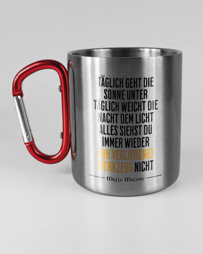 Titelbild, das die linke Seite der beidseitig bedruckten Edelstahltasse von Maondo mit dem Design Wegzeug in der Farbe Metallic-Red auf einem Holztisch zeigt