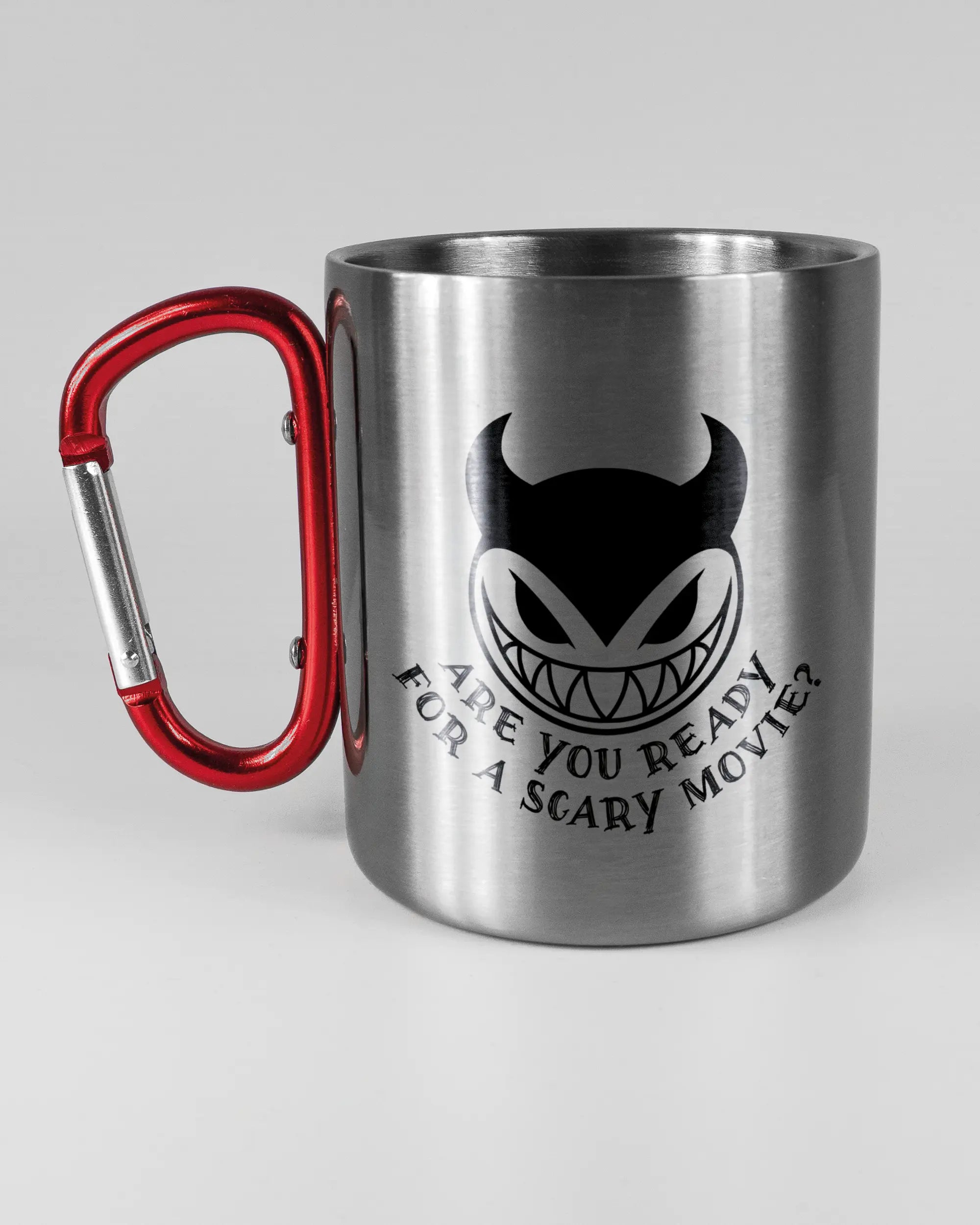 Titelbild, das die linke Seite der beidseitig bedruckten Edelstahltasse von Maondo mit dem Design Scary Movie in der Farbe Metallic-Red auf einem Holztisch zeigt