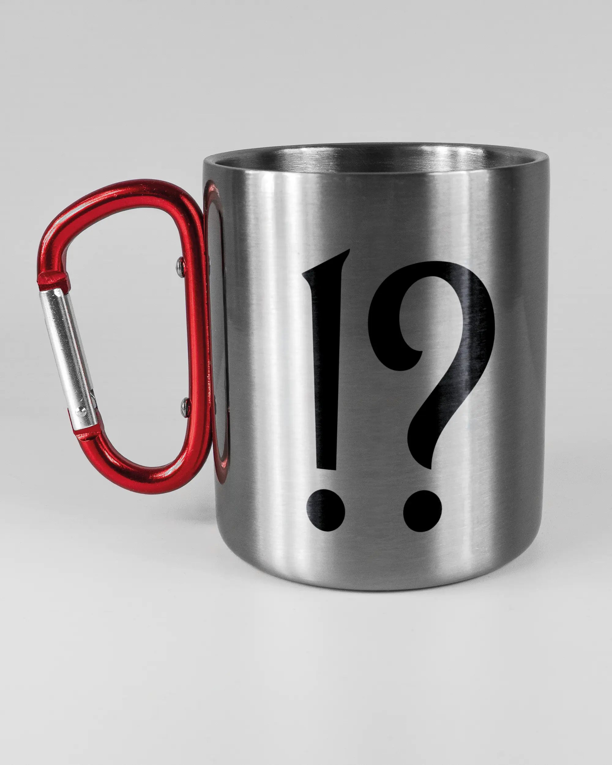 Titelbild, das die linke Seite der beidseitig bedruckten Edelstahltasse von Maondo mit dem Design WHAT in der Farbe Metallic-Red auf einem Holztisch zeigt