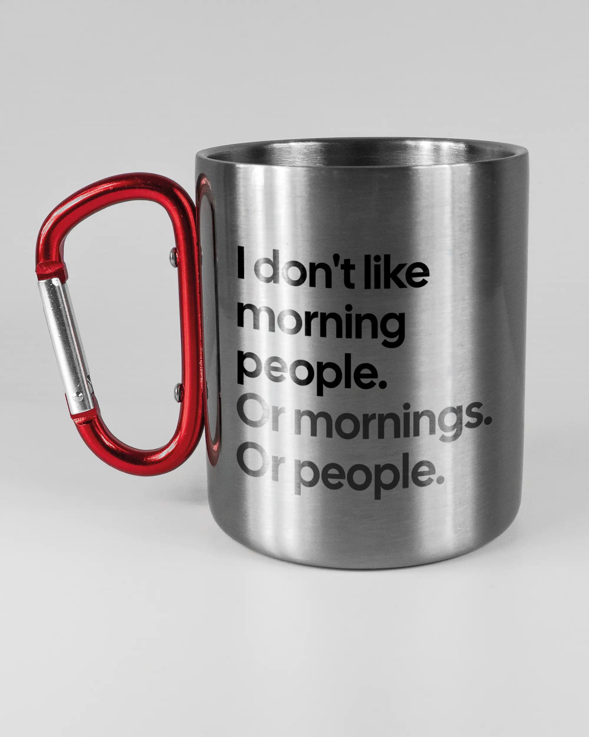 Titelbild, das die linke Seite der beidseitig bedruckten Edelstahltasse von Maondo mit dem Design Morning Person in der Farbe Metallic-Red auf einem Holztisch zeigt