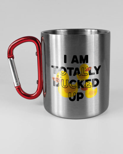 Titelbild, das die linke Seite der beidseitig bedruckten Edelstahltasse von Maondo mit dem Design Ducked Up in der Farbe Metallic-Red auf einem Holztisch zeigt