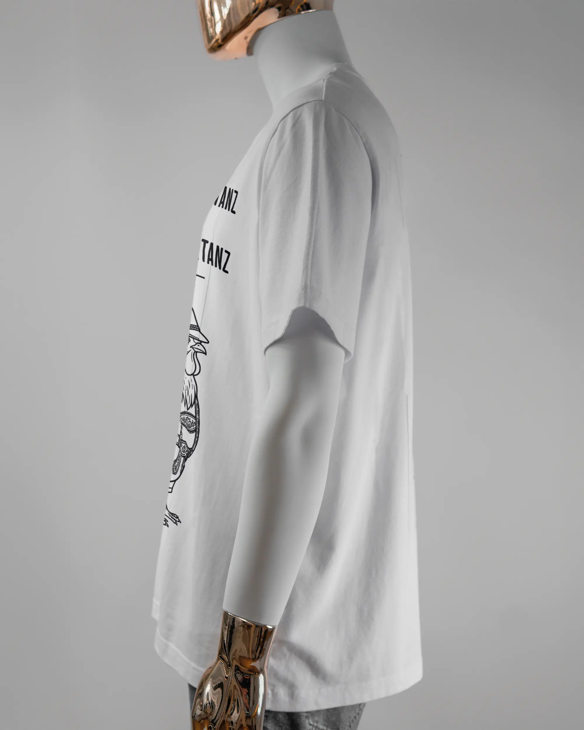 Seitenansicht des Organic Unisex T-Shirt Relaxed von Maondo mit dem Design Trachtentanz vorne in der Farbe White und in der Größe L getragen von einer maskulinen Puppe