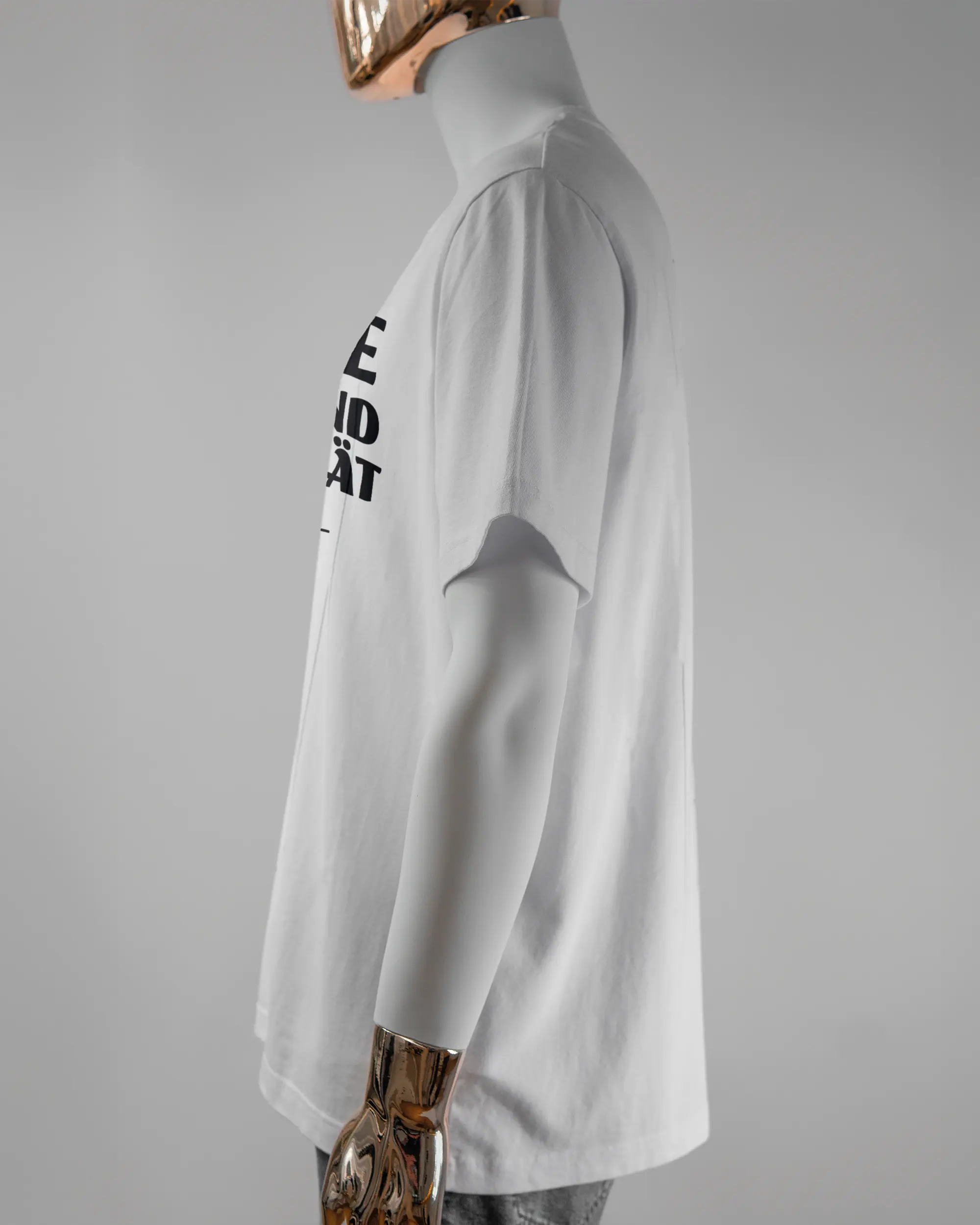 Seitenansicht des Organic Unisex T-Shirt Relaxed von Maondo mit dem Design Keine Eile vorne in der Farbe White und in der Größe L getragen von einer maskulinen Puppe