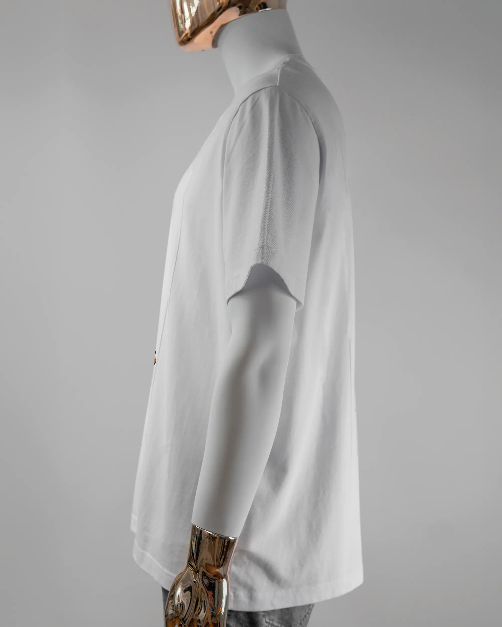 Seitenansicht des Organic Unisex T-Shirt Relaxed von Maondo mit dem Design I give a duck vorne in der Farbe White und in der Größe L getragen von einer maskulinen Puppe