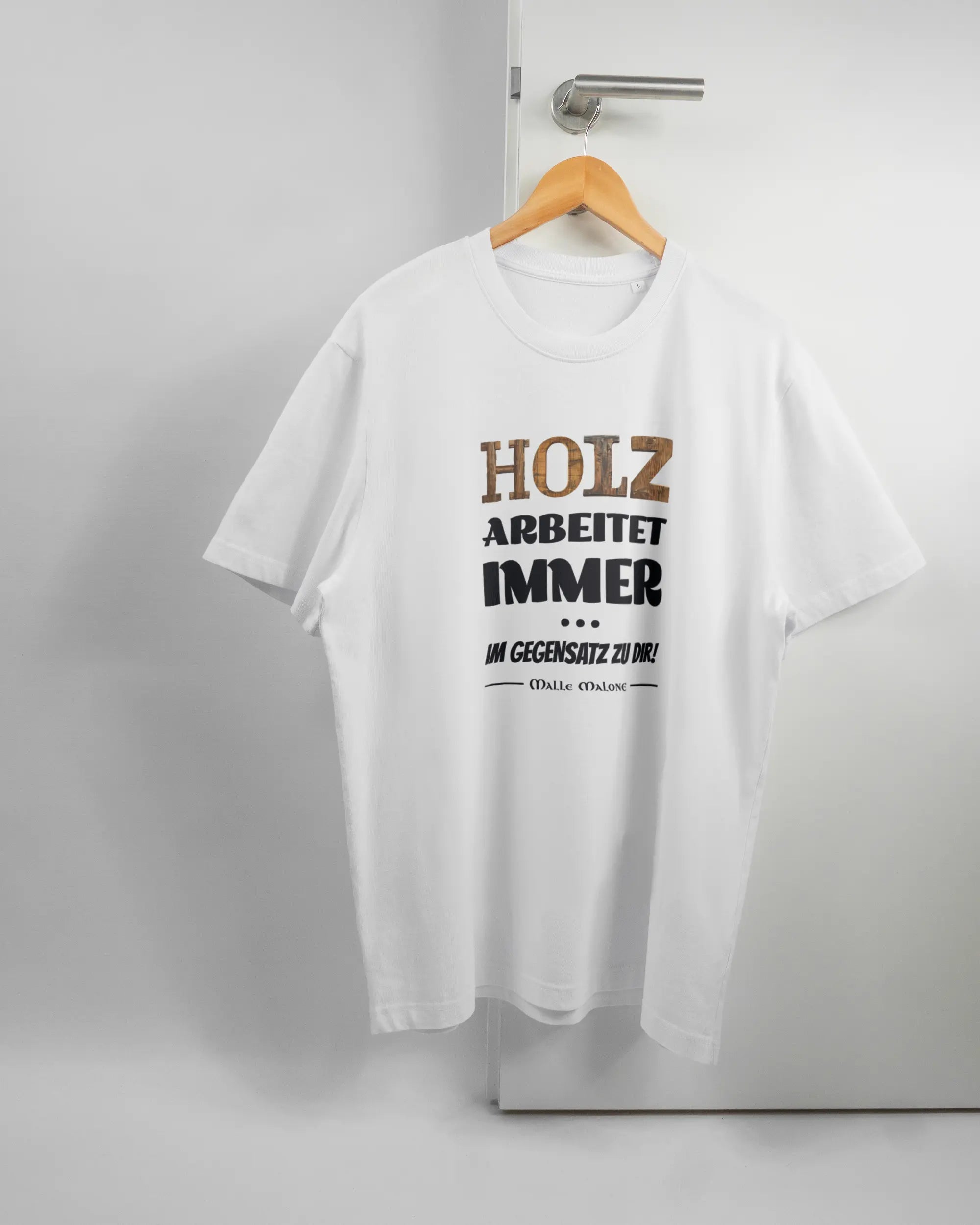 Vorderseite des Organic Unisex T-Shirt Relaxed von Maondo mit dem Design Holzarbeit in der Farbe White und in der Größe L auf einem Bügel an der Türklinke aufgehängt