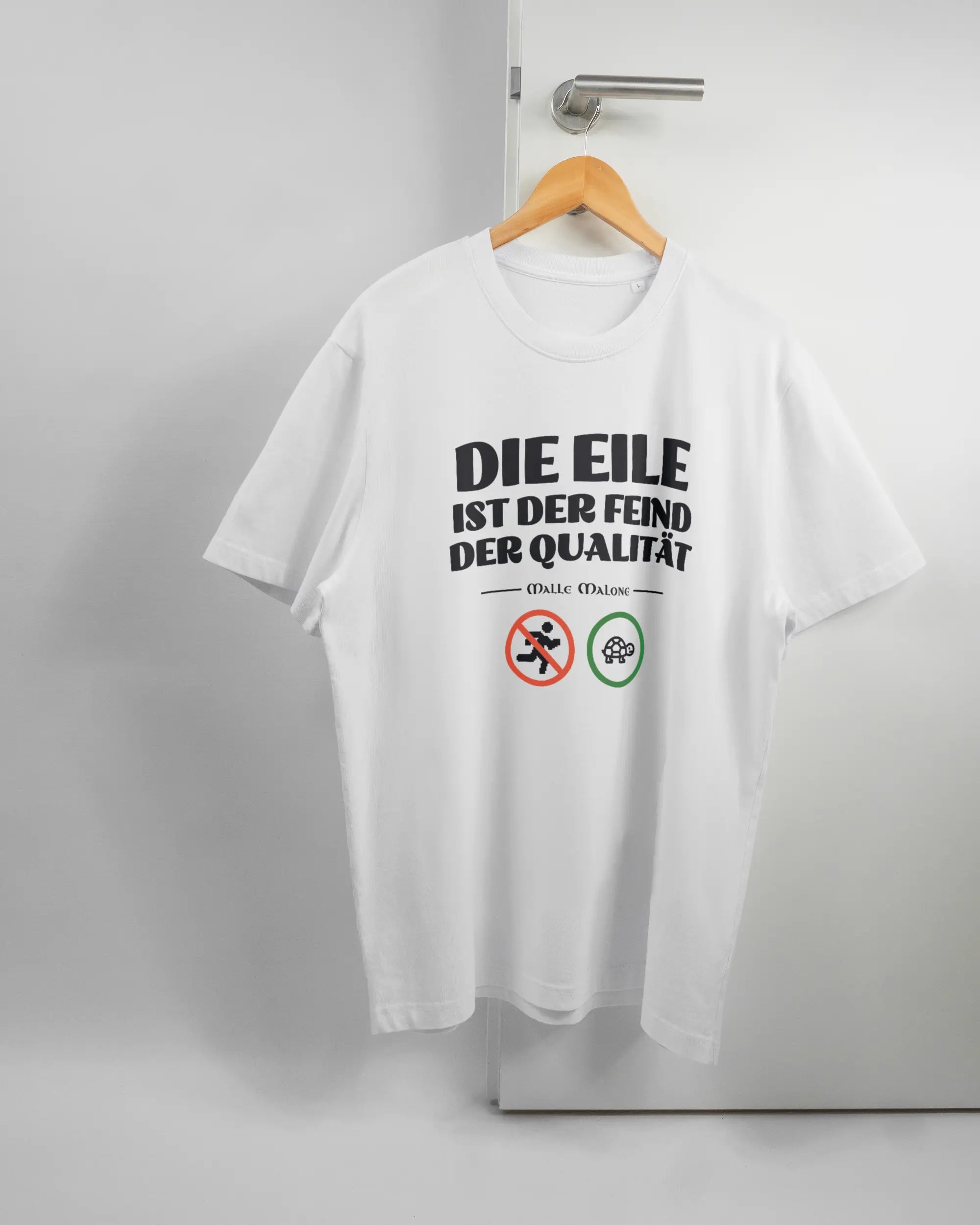 Vorderseite des Organic Unisex T-Shirt Relaxed von Maondo mit dem Design Keine Eile in der Farbe White und in der Größe L auf einem Bügel an der Türklinke aufgehängt