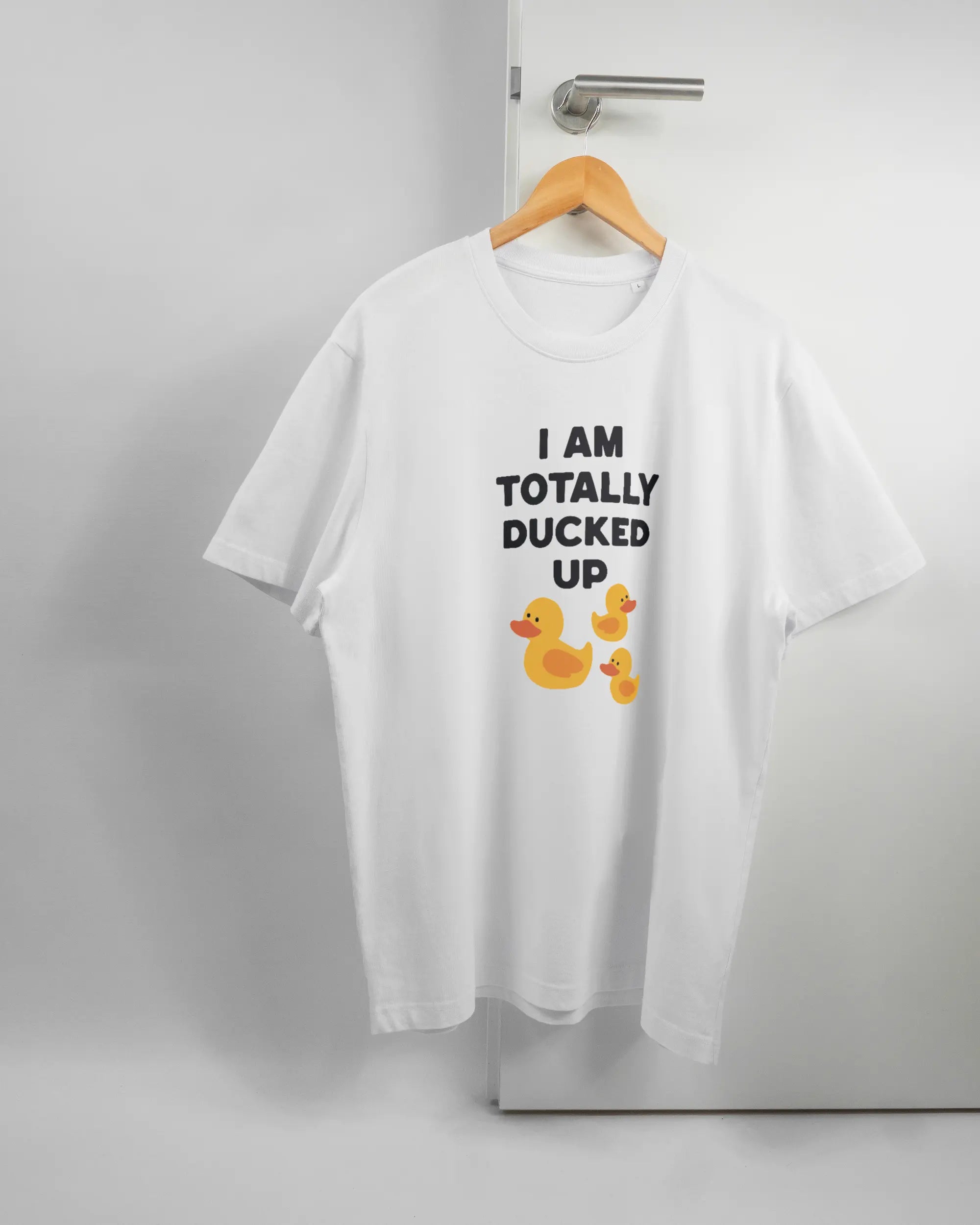 Vorderseite des Organic Unisex T-Shirt Relaxed von Maondo mit dem Design Ducked Up in der Farbe White und in der Größe L auf einem Bügel an der Türklinke aufgehängt