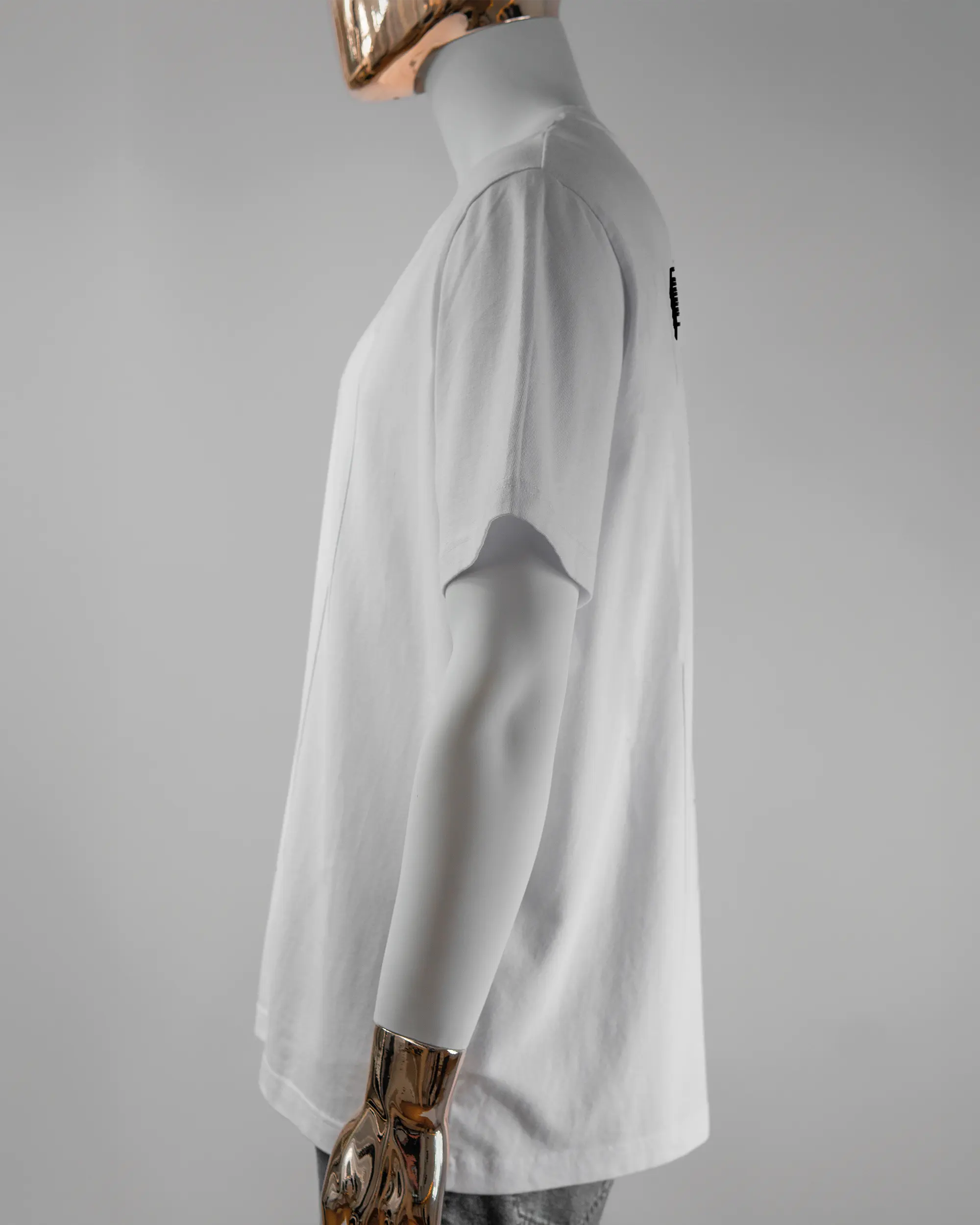 Seitenansicht des Organic Unisex T-Shirt Relaxed von Maondo mit dem Design Hidden Message hinten in der Farbe White und in der Größe L getragen von einer maskulinen Puppe