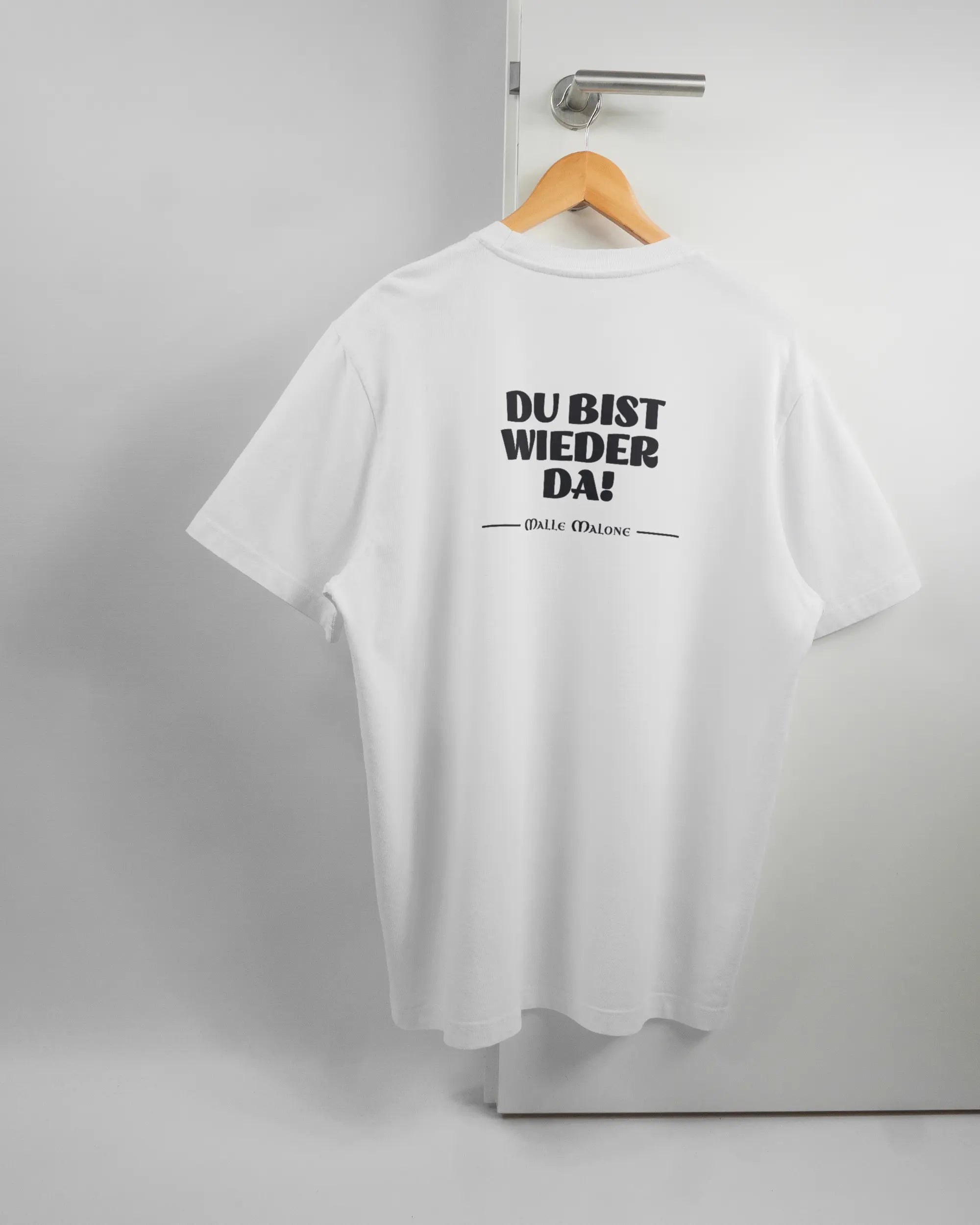 Rückseite des Organic Unisex T-Shirt Relaxed von Maondo mit dem Design Wieder da in der Farbe White und in der Größe L auf einem Bügel an der Türklinke aufgehängt