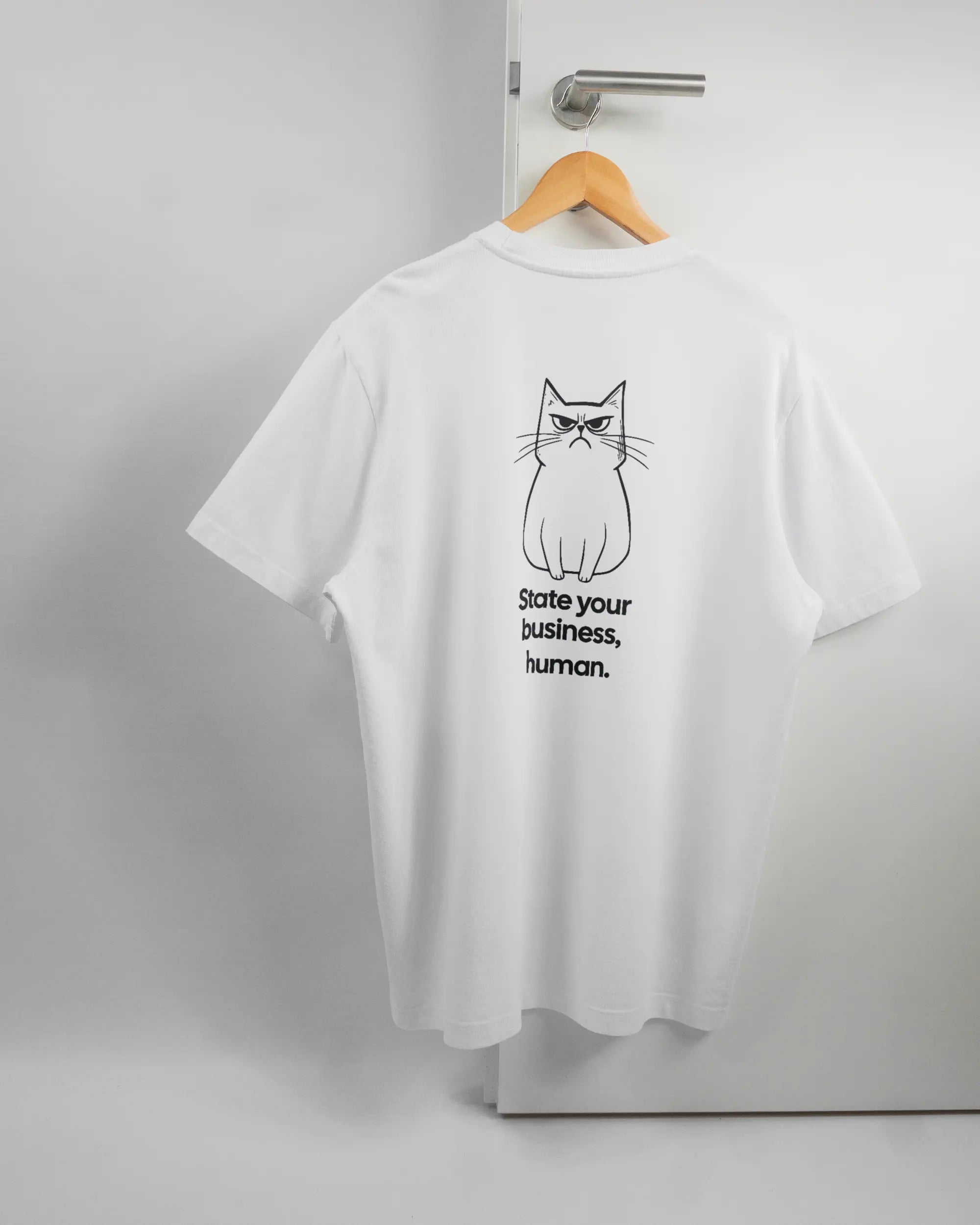 Rückseite des Organic Unisex T-Shirt Relaxed von Maondo mit dem Design Grumpy Purr in der Farbe White und in der Größe L auf einem Bügel an der Türklinke aufgehängt