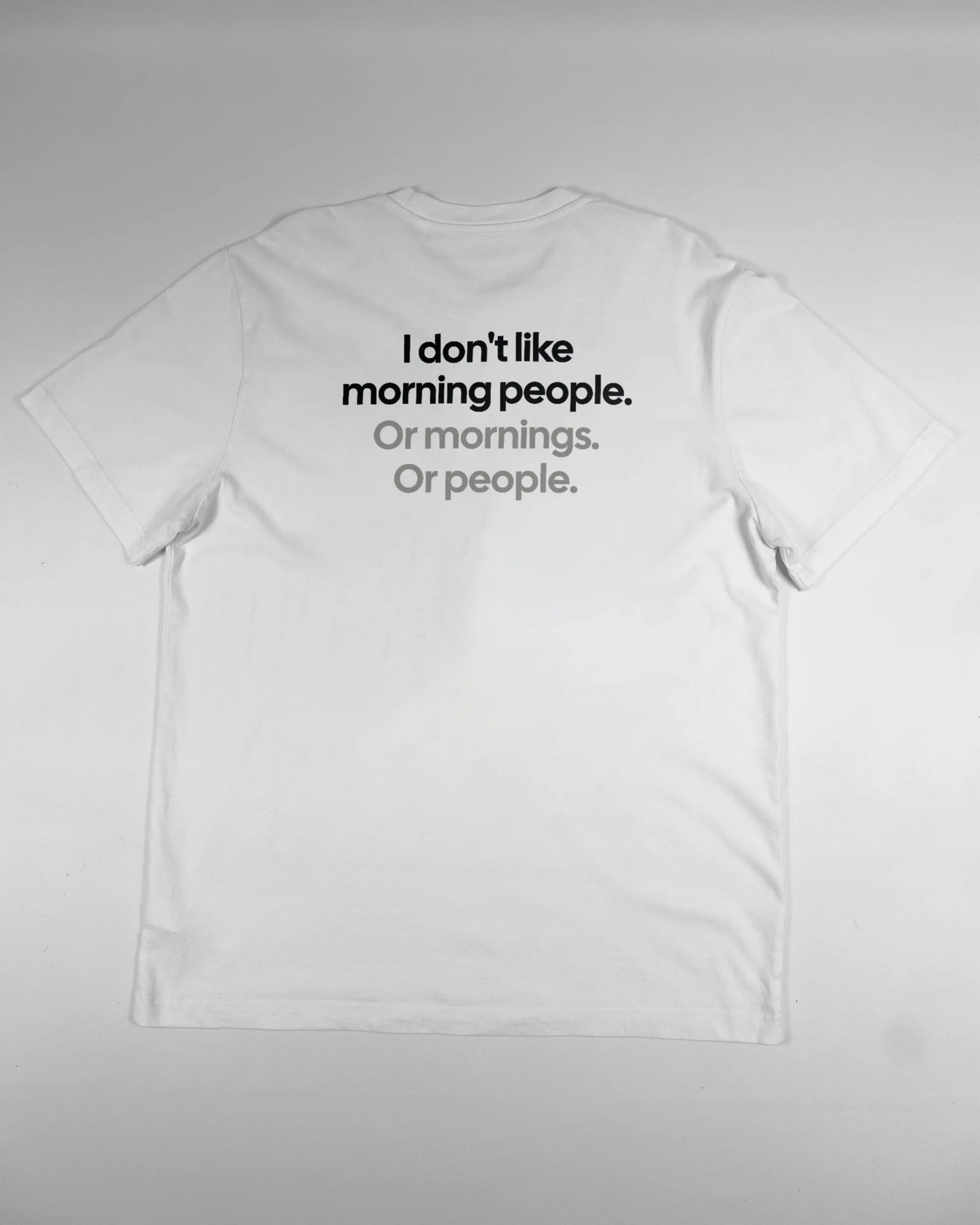 Rückseite des Organic Unisex T-Shirt Relaxed von Maondo mit dem Design Morning Person in der Farbe White und in der Größe L flach auf den Boden gelegt