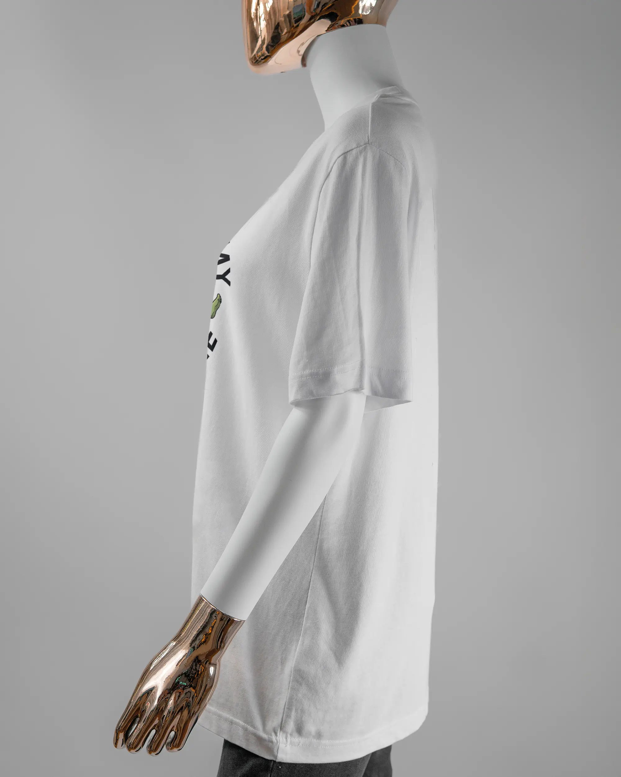 Seitenansicht des Organic Unisex T-Shirt Relaxed von Maondo mit dem Design Brocco-Lee vorne in der Farbe White und in der Größe S getragen von einer femininen Puppe