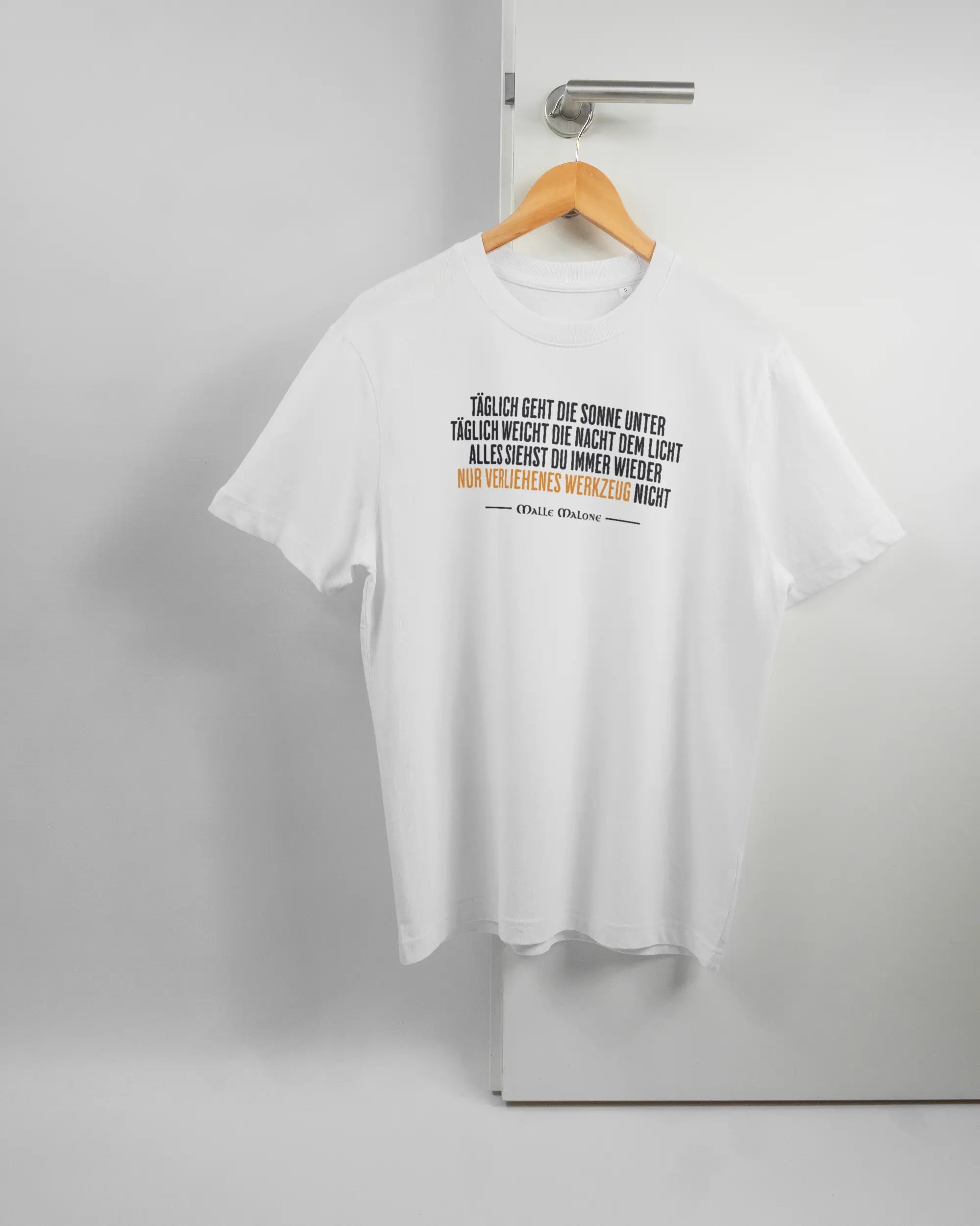 Vorderseite des Organic Unisex T-Shirt Relaxed von Maondo mit dem Design Wegzeug in der Farbe White und in der Größe S auf einem Bügel an der Türklinke aufgehängt