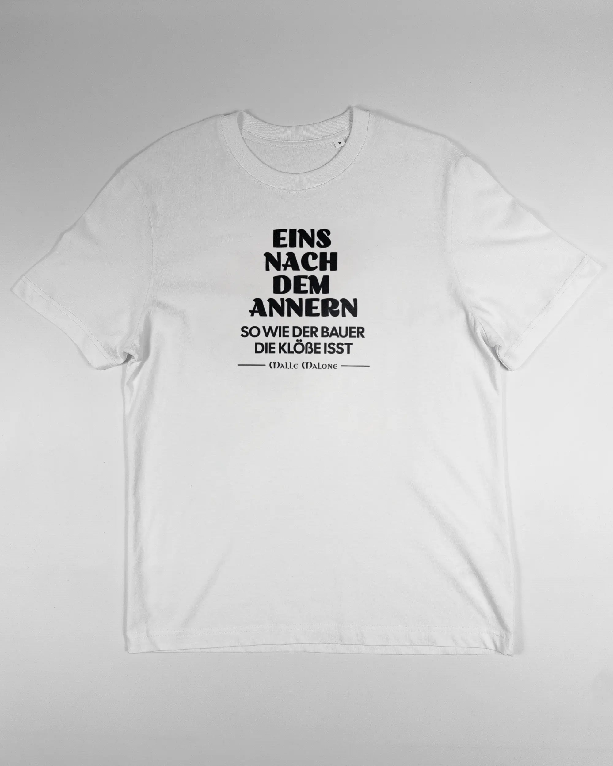 Vorderseite des Organic Unisex T-Shirt Relaxed von Maondo mit dem Design Eins nach dem Annern in der Farbe White und in der Größe S flach auf den Boden gelegt