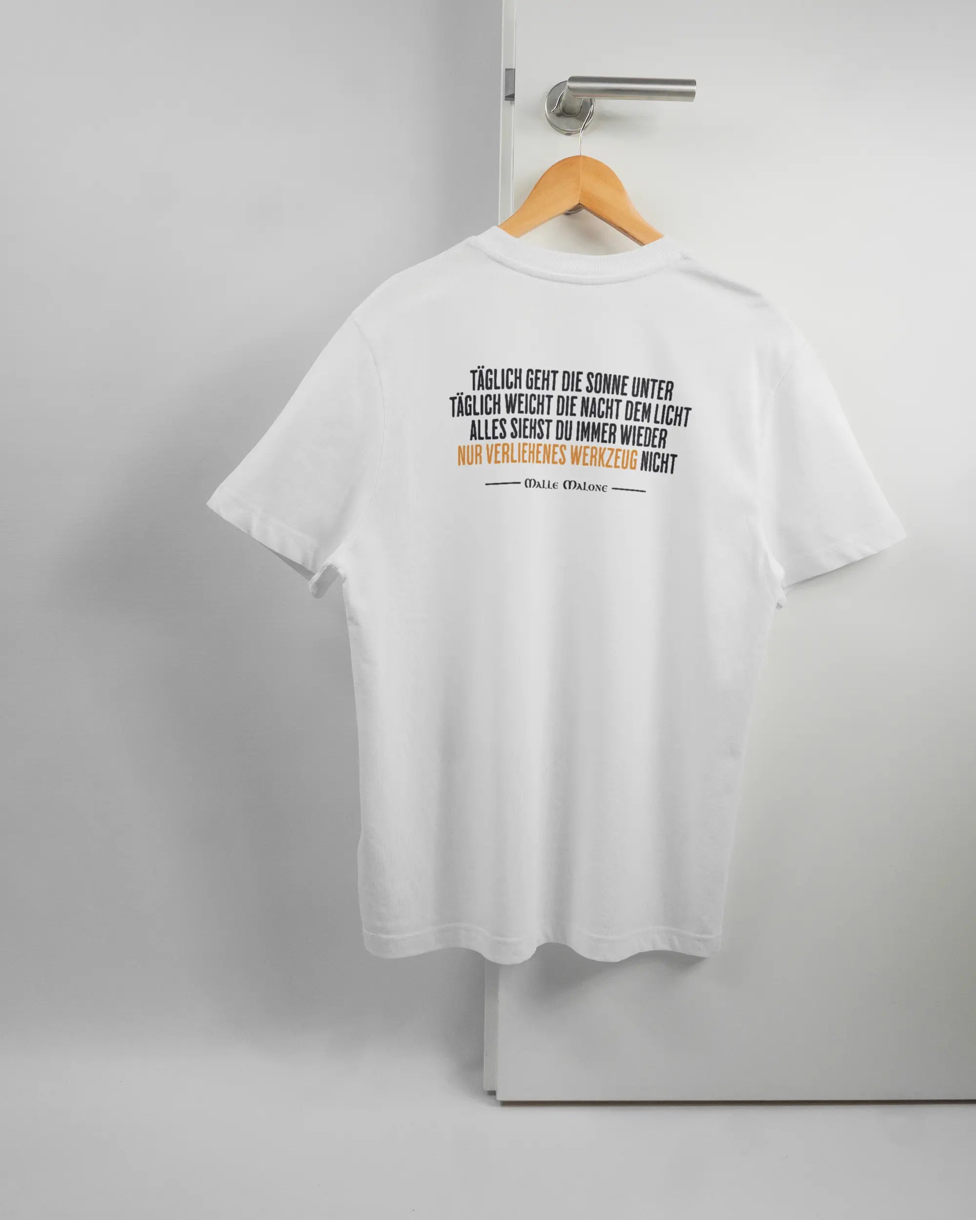 Rückseite des Organic Unisex T-Shirt Relaxed von Maondo mit dem Design Wegzeug in der Farbe White und in der Größe S auf einem Bügel an der Türklinke aufgehängt