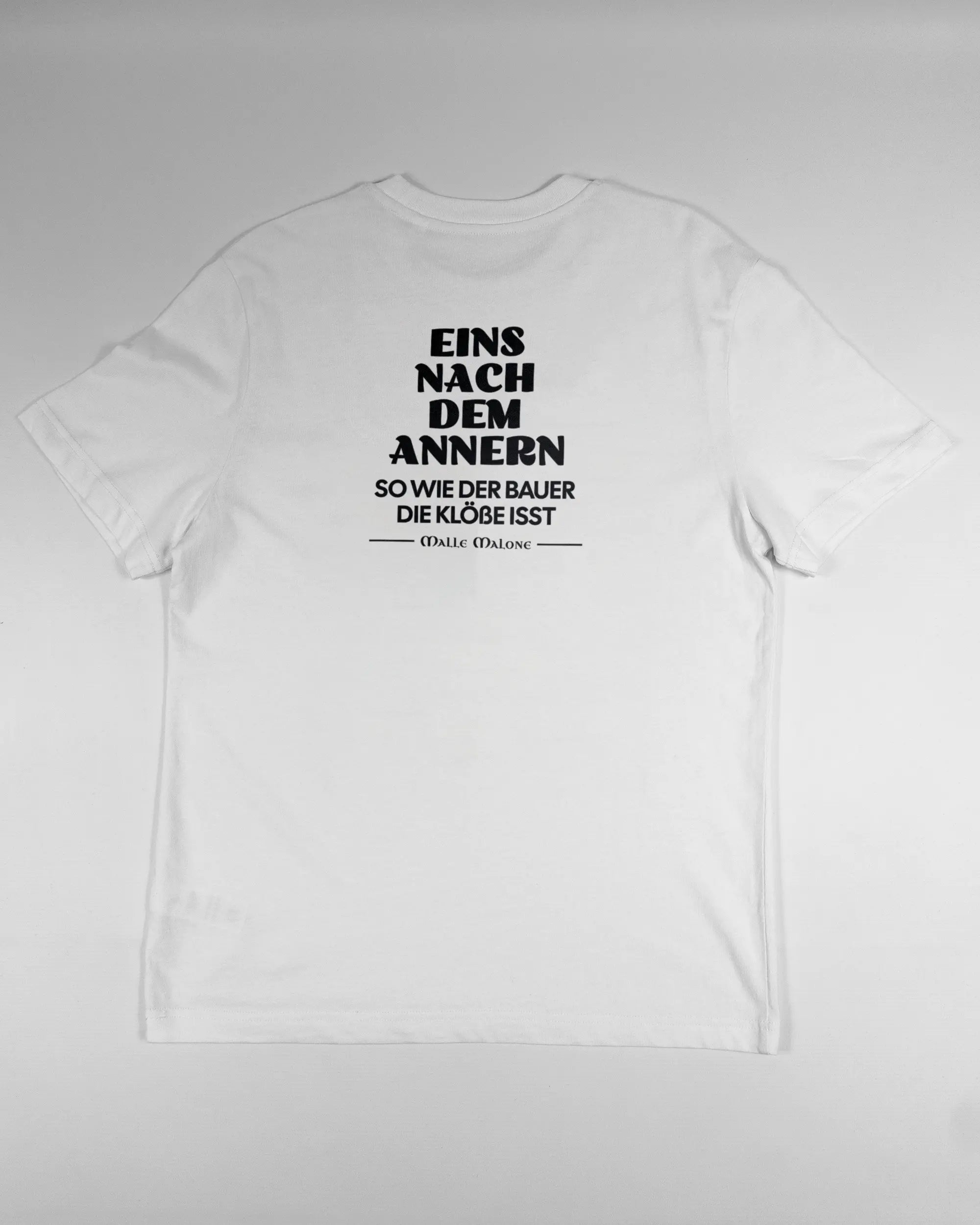 Rückseite des Organic Unisex T-Shirt Relaxed von Maondo mit dem Design Eins nach dem Annern in der Farbe White und in der Größe S flach auf den Boden gelegt