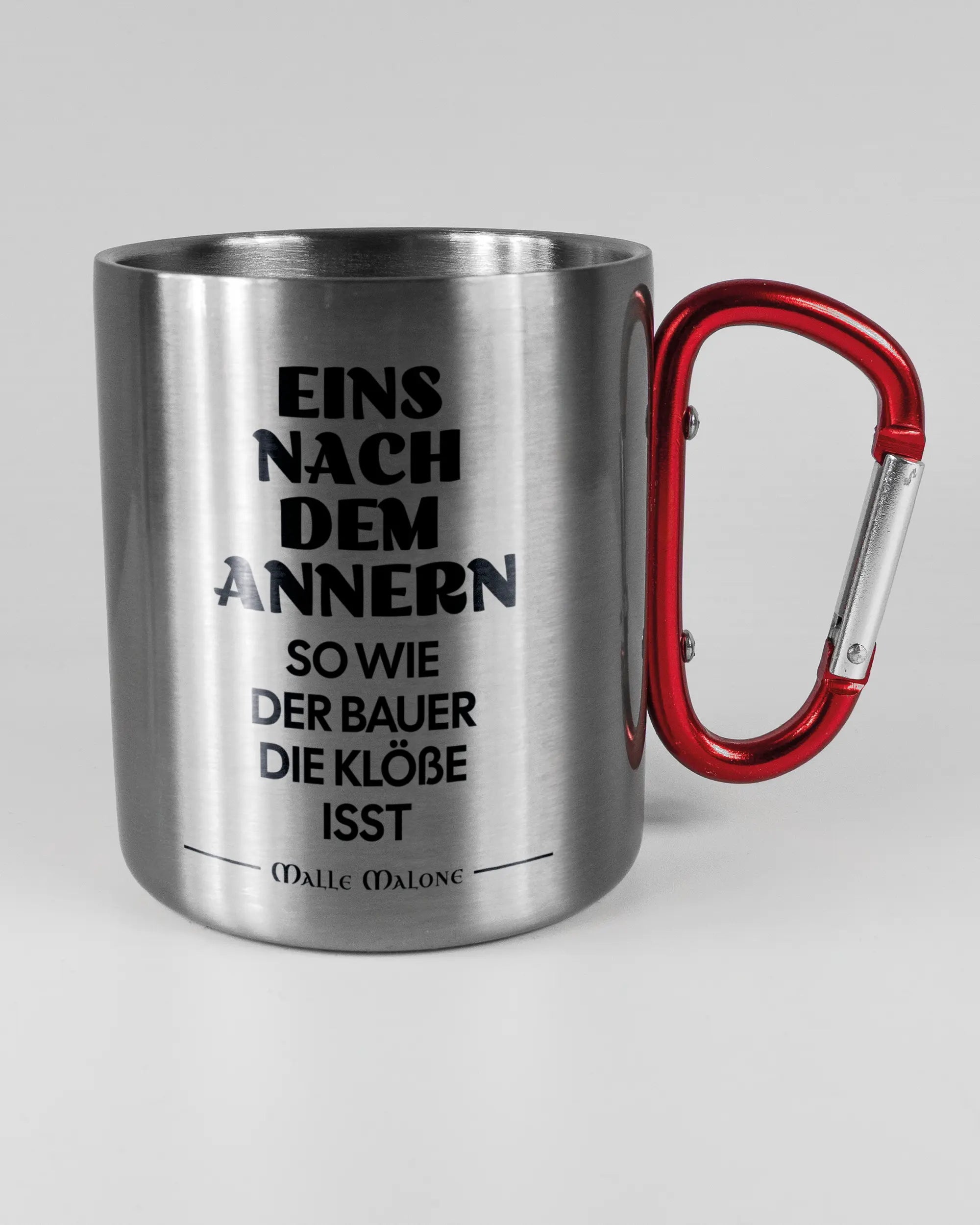 Alternativbild, das die rechte Seite der beidseitig bedruckten Edelstahltasse von Maondo mit dem Design Eins nach dem Annern in der Farbe Metallic-Red auf einem Holztisch zeigt