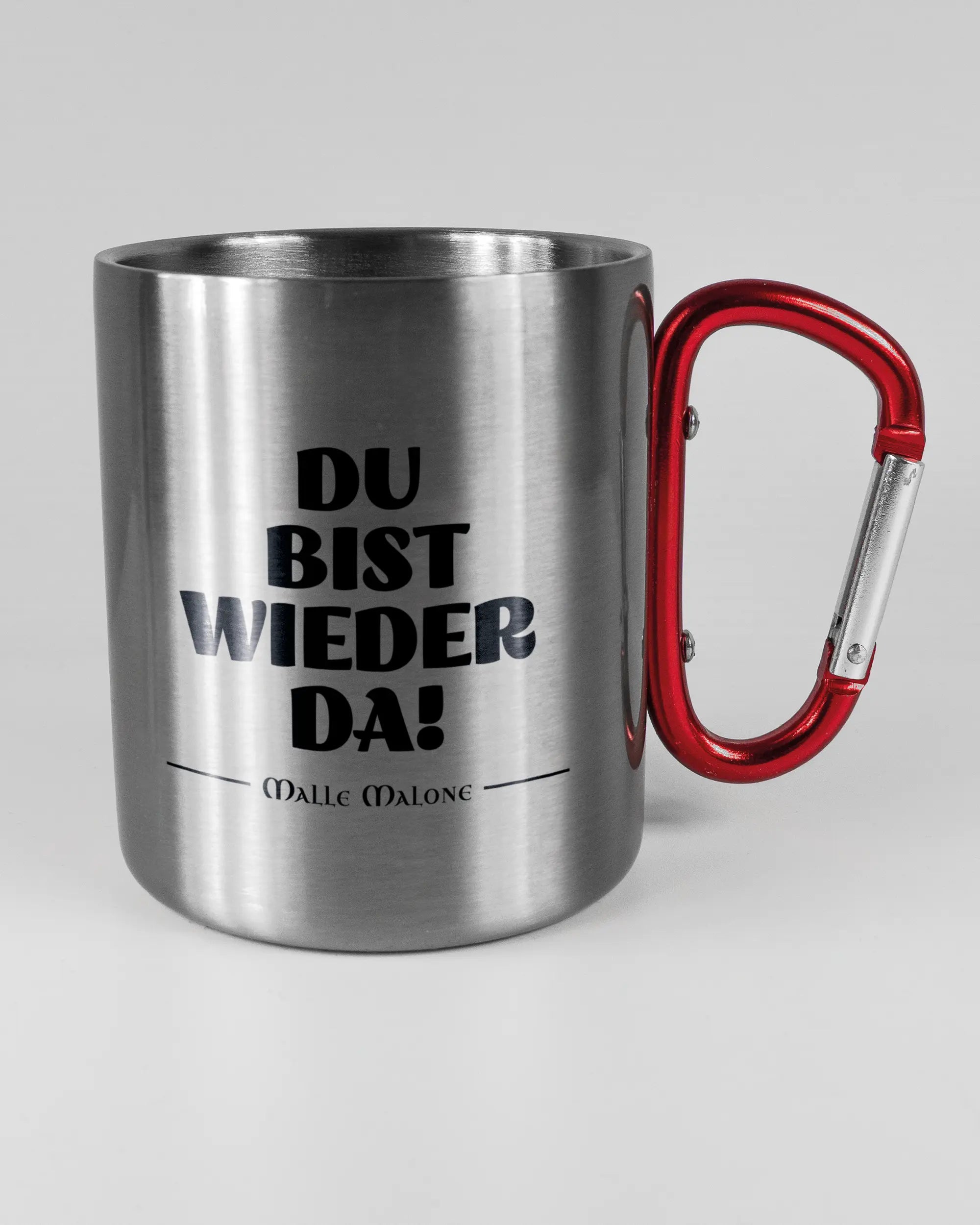 Alternativbild, das die rechte Seite der beidseitig bedruckten Edelstahltasse von Maondo mit dem Design Wieder da in der Farbe Metallic-Red auf einem Holztisch zeigt