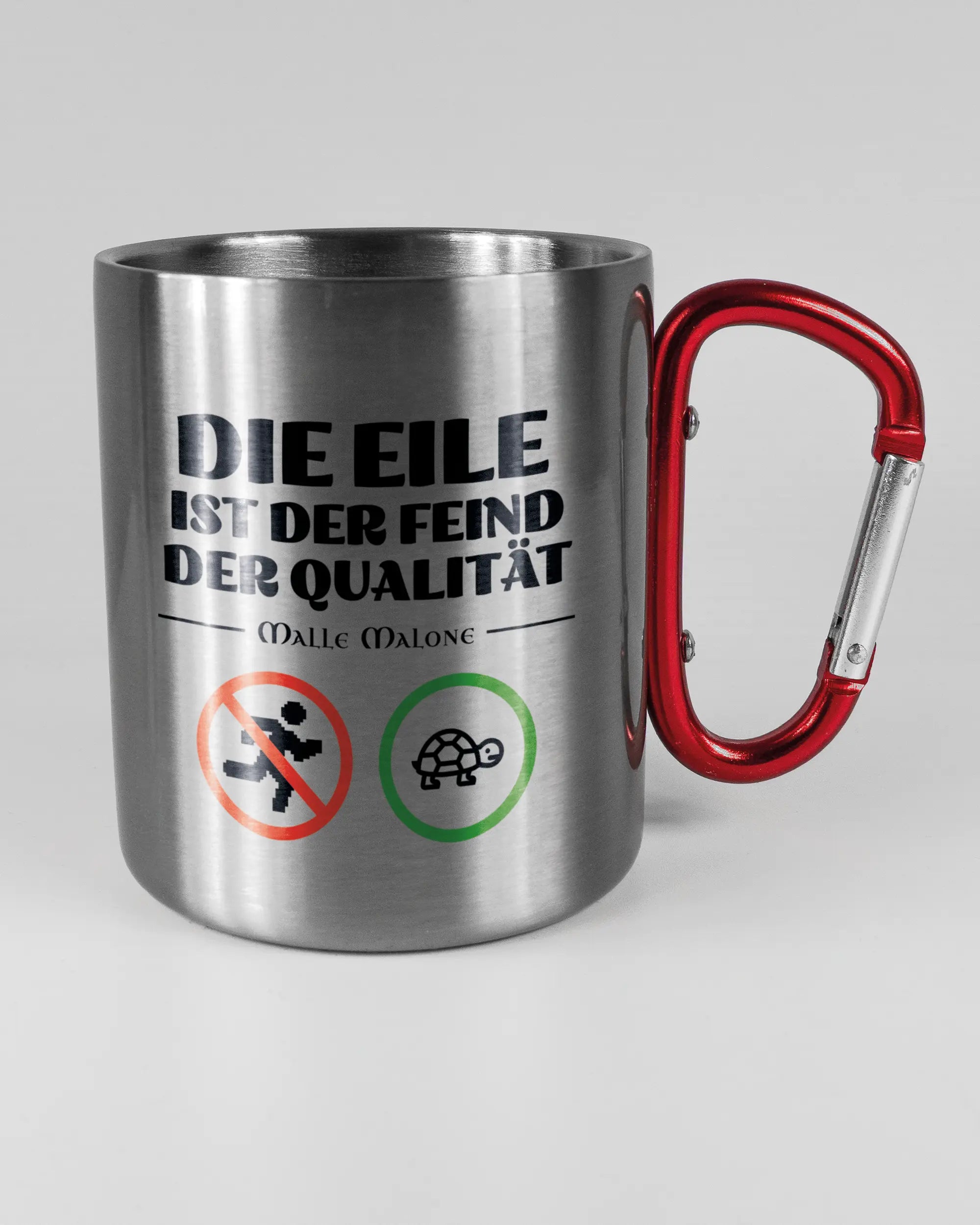 Alternativbild, das die rechte Seite der beidseitig bedruckten Edelstahltasse von Maondo mit dem Design Keine Eile in der Farbe Metallic-Red auf einem Holztisch zeigt
