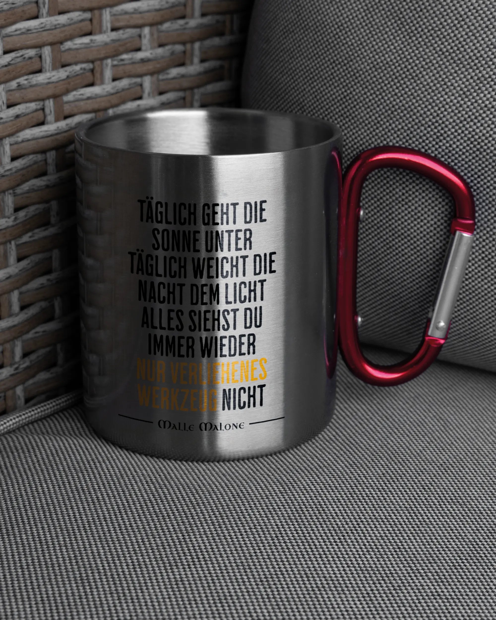 Ansicht der rechten Seite der beidseitig bedruckten Edelstahltasse von Maondo auf einem Balkonmöbel bzw. Campingstuhl mit dem Design Wegzeug in der Farbe Metallic-Red