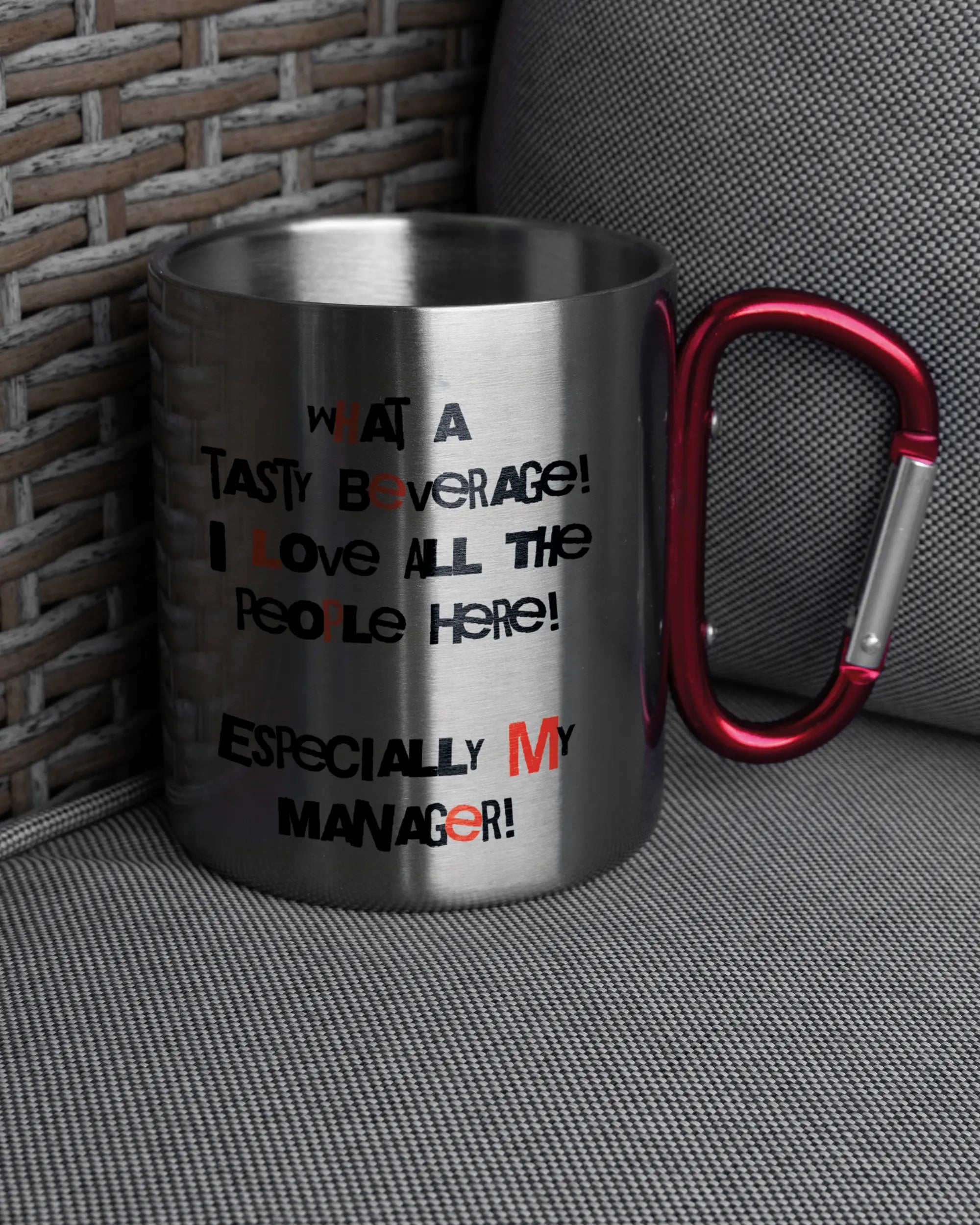 Ansicht der rechten Seite der beidseitig bedruckten Edelstahltasse von Maondo auf einem Balkonmöbel bzw. Campingstuhl mit dem Design Help me in der Farbe Metallic-Red