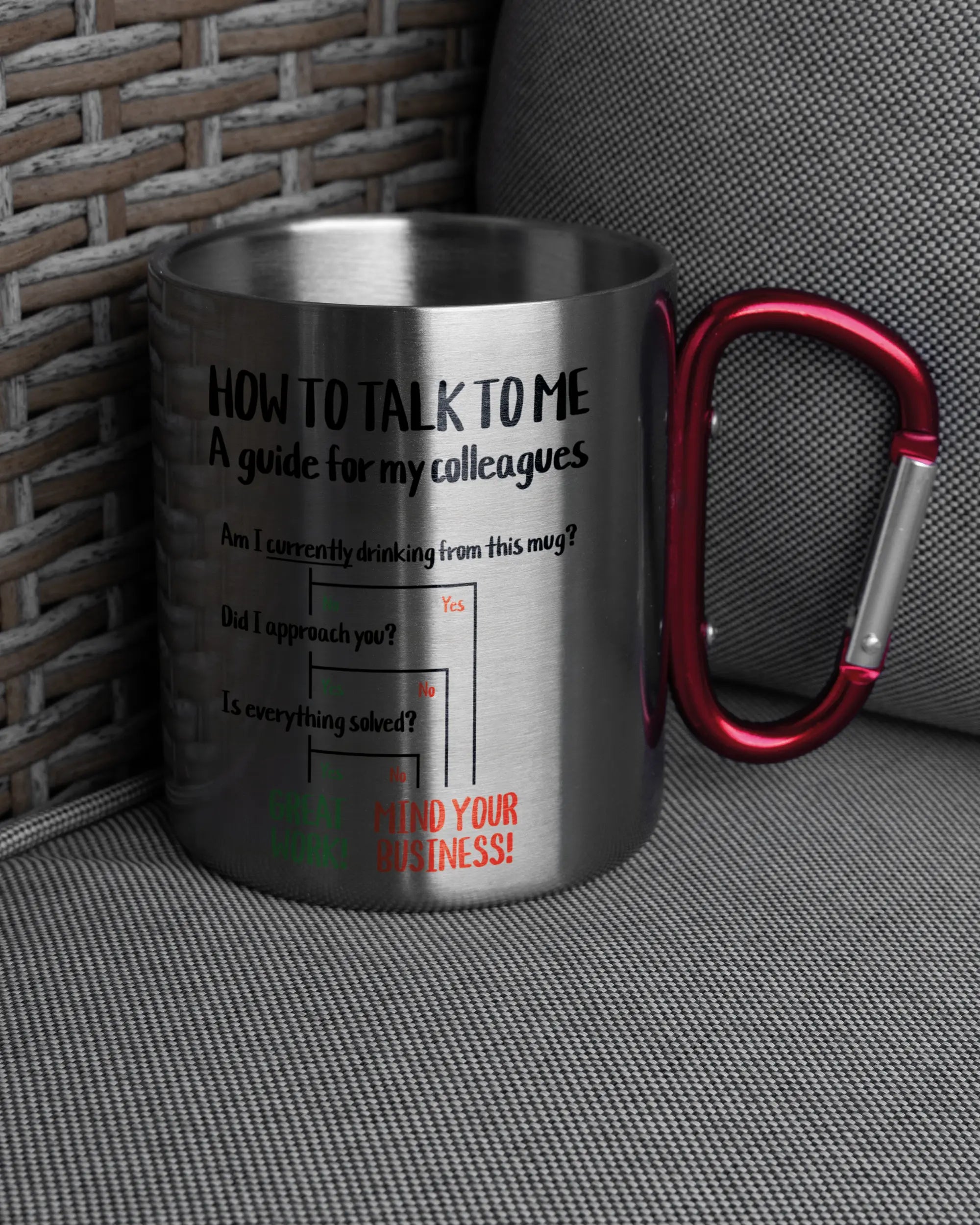 Ansicht der rechten Seite der beidseitig bedruckten Edelstahltasse von Maondo auf einem Balkonmöbel bzw. Campingstuhl mit dem Design Colleagues Guide in der Farbe Metallic-Red