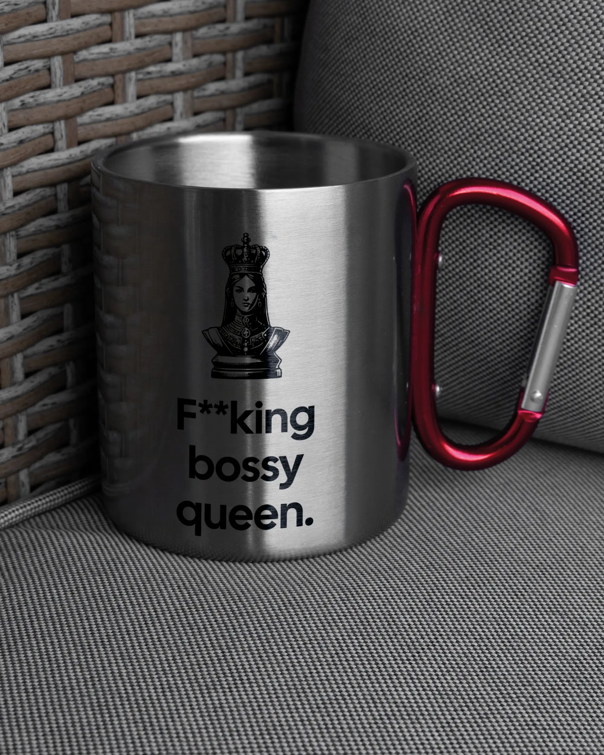 Ansicht der rechten Seite der beidseitig bedruckten Edelstahltasse von Maondo auf einem Balkonmöbel bzw. Campingstuhl mit dem Design Bossy Queen in der Farbe Metallic-Red