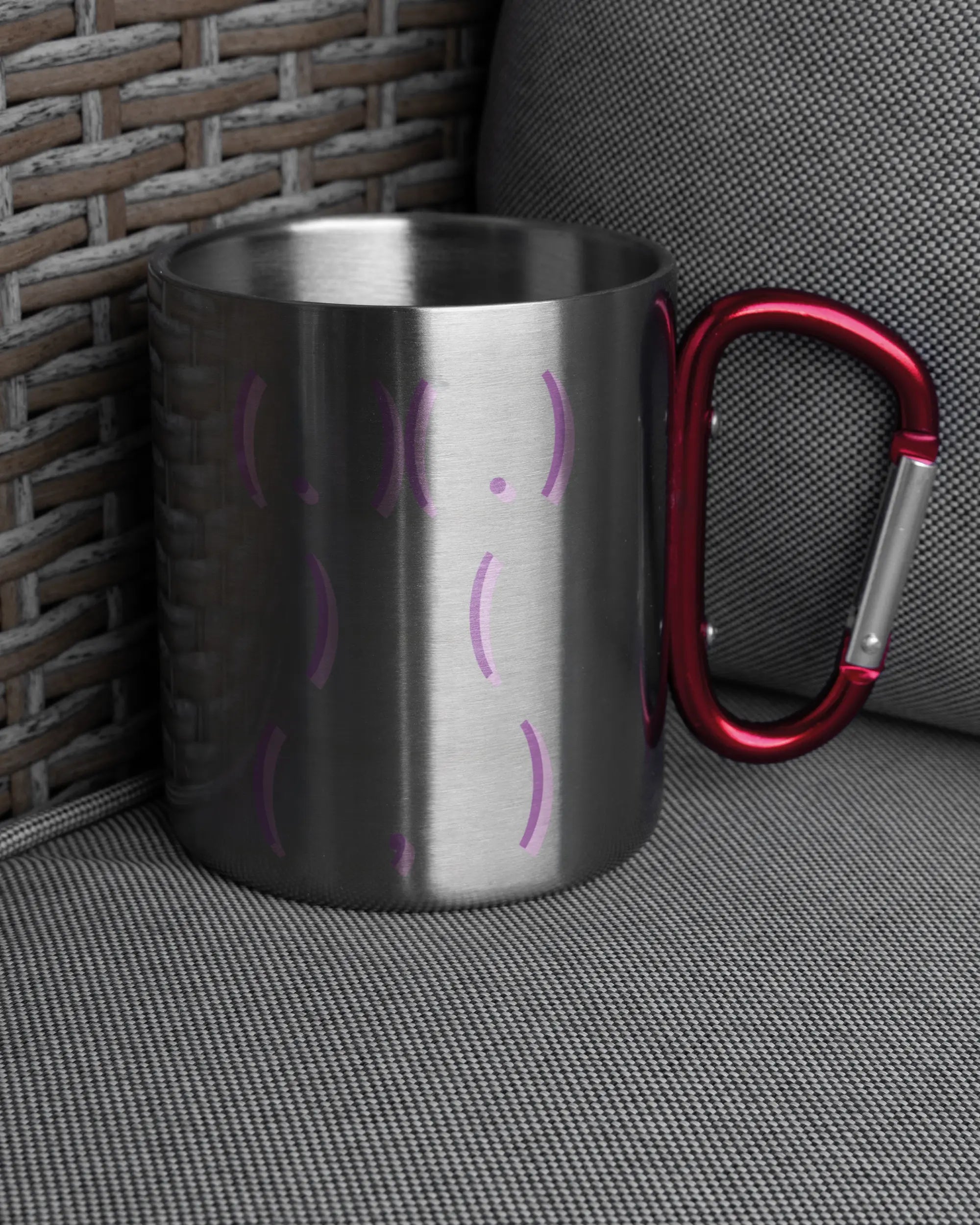 Ansicht der rechten Seite der beidseitig bedruckten Edelstahltasse von Maondo auf einem Balkonmöbel bzw. Campingstuhl mit dem Design Body Language in der Farbe Metallic-Red