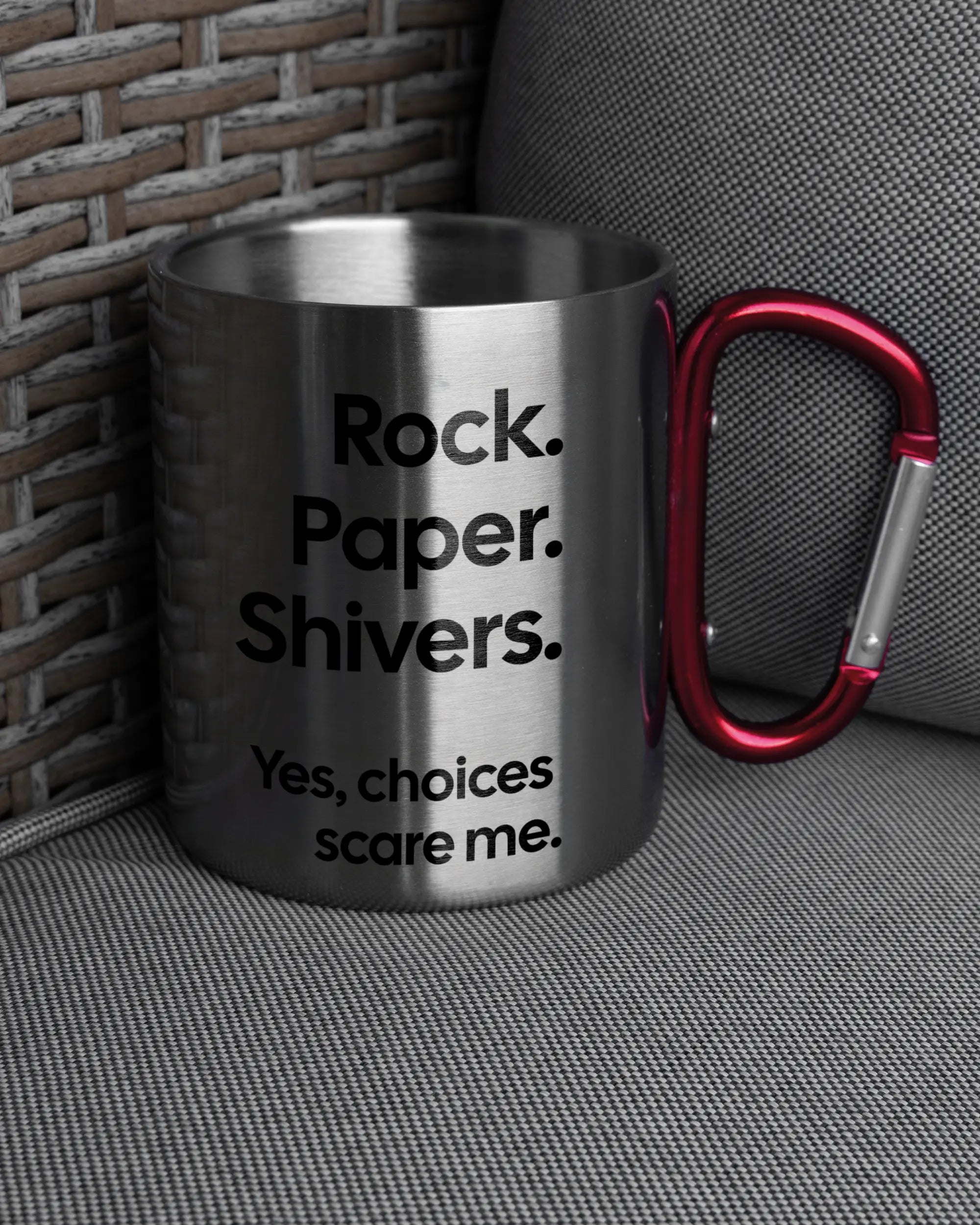 Ansicht der rechten Seite der beidseitig bedruckten Edelstahltasse von Maondo auf einem Balkonmöbel bzw. Campingstuhl mit dem Design Rock Paper Shivers in der Farbe Metallic-Red