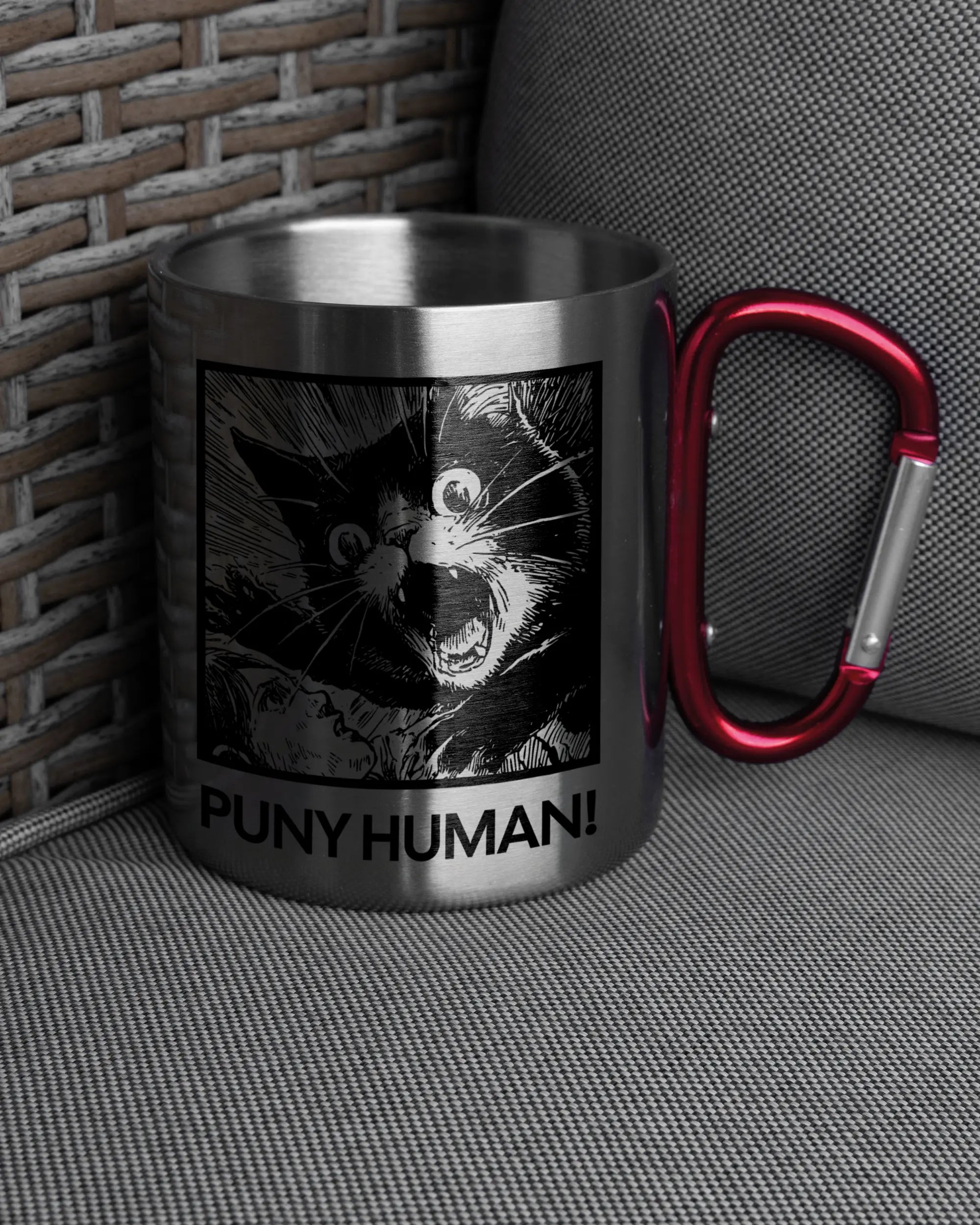 Ansicht der rechten Seite der beidseitig bedruckten Edelstahltasse von Maondo auf einem Balkonmöbel bzw. Campingstuhl mit dem Design Puny Human in der Farbe Metallic-Red