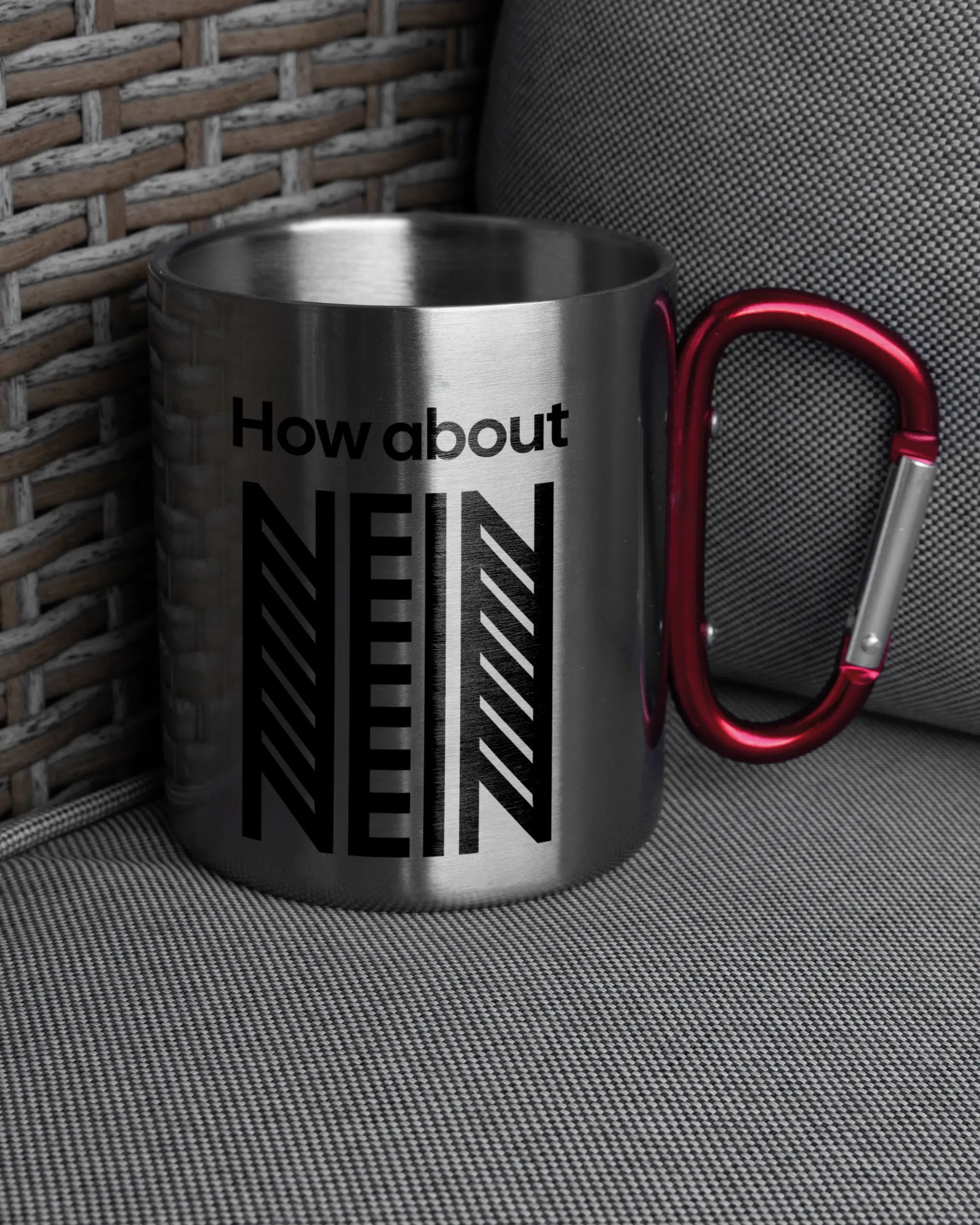 Ansicht der rechten Seite der beidseitig bedruckten Edelstahltasse von Maondo auf einem Balkonmöbel bzw. Campingstuhl mit dem Design How about nein in der Farbe Metallic-Red