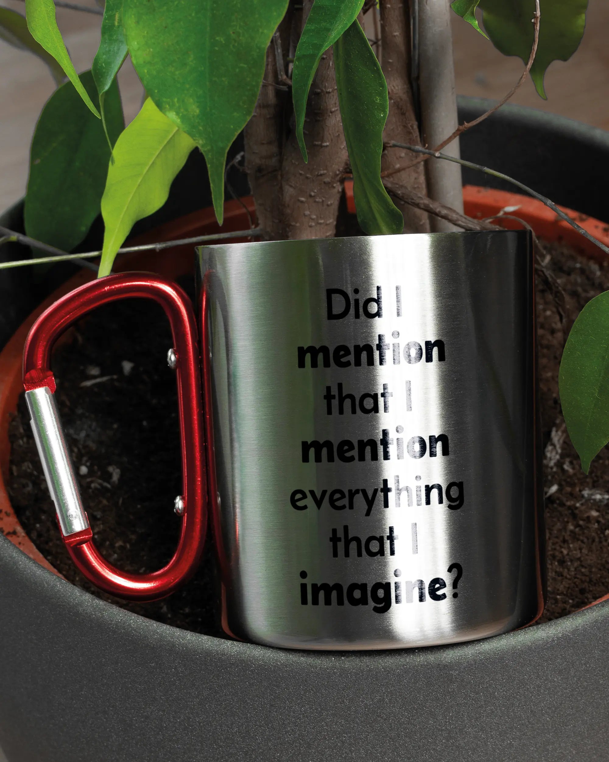 Aufnahme der linken Seite der beidseitig bedruckten Edelstahltasse von Maondo mit dem Design Did I mention in der Farbe Metallic-Red in einem Blumentopf