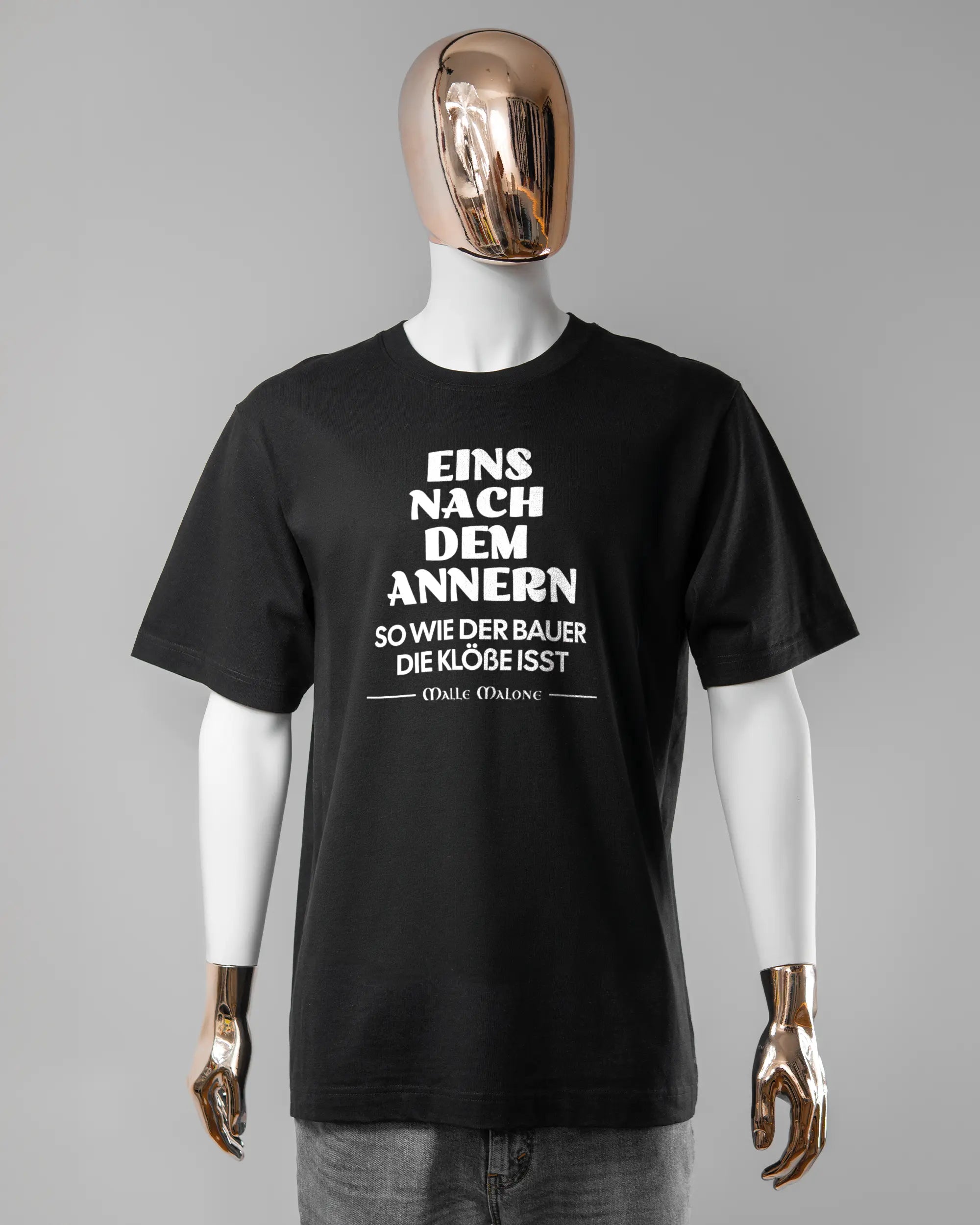 Vorderseite des Organic Unisex T-Shirt Heavy Oversized von Maondo mit dem Design Eins nach dem Annern in der Farbe Black und in der Größe L getragen von einer maskulinen Puppe